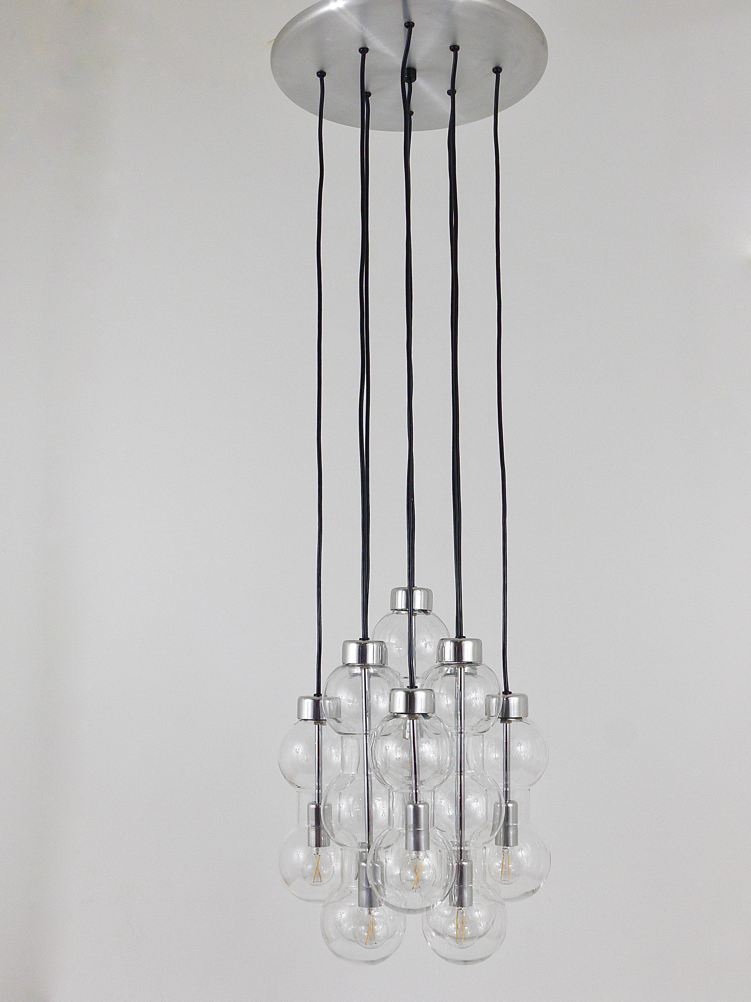A beautiful large Cascade chandelier / pendant lamp from the 1960s, executed by Doria, Germany. This impressive chandelier has nine cascading strands with five double and four triple hourglass-shaped clear glass bubble shades on a chrome-plated