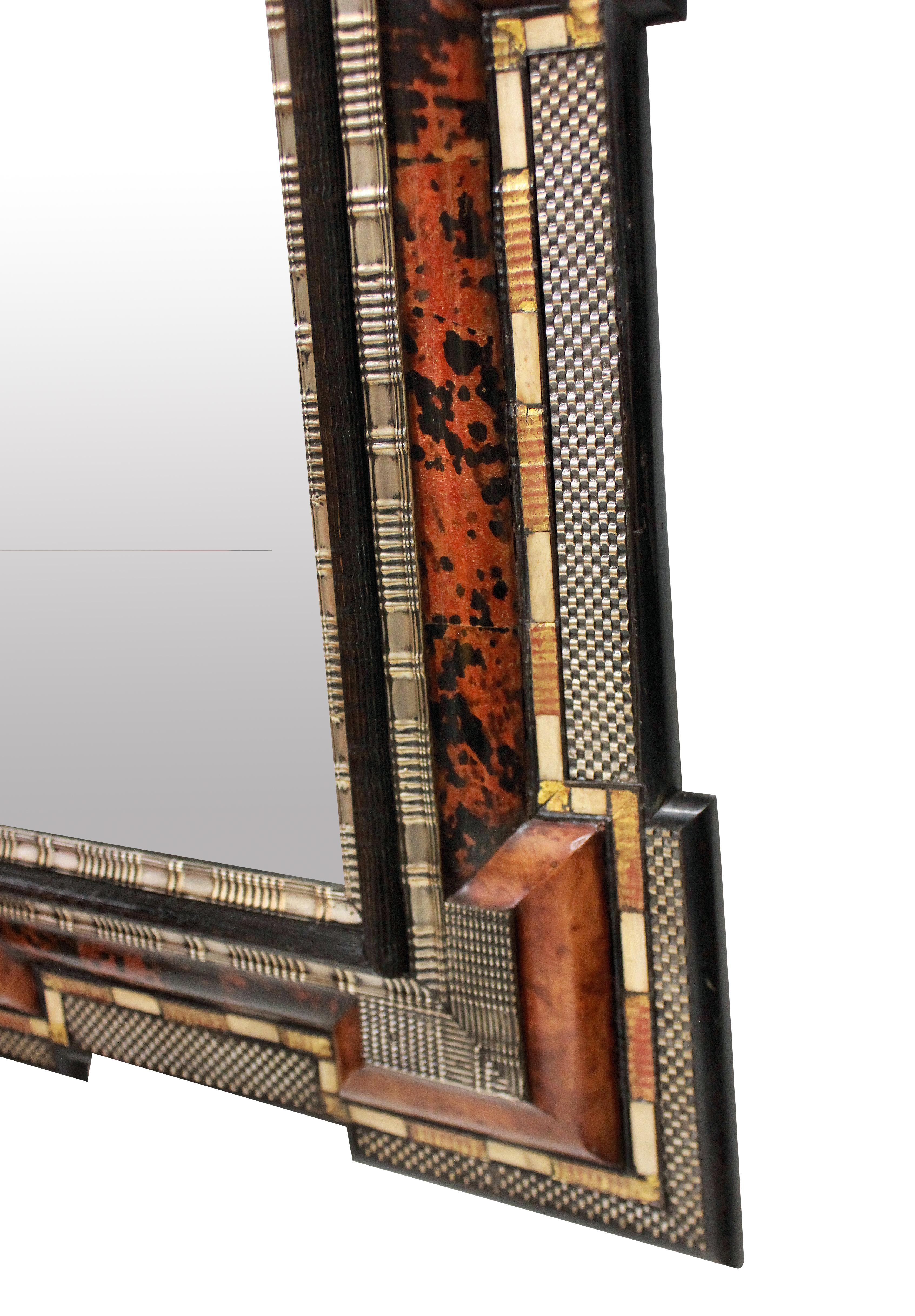 An impressive Dutch 17th century style ebonized cushion mirror in faux tortoiseshell, with repousse silver, giltwood and bone detailing.