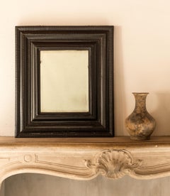 Splendido specchio barocco fiammingo con cornice a ondulature e finitura ebanizzata