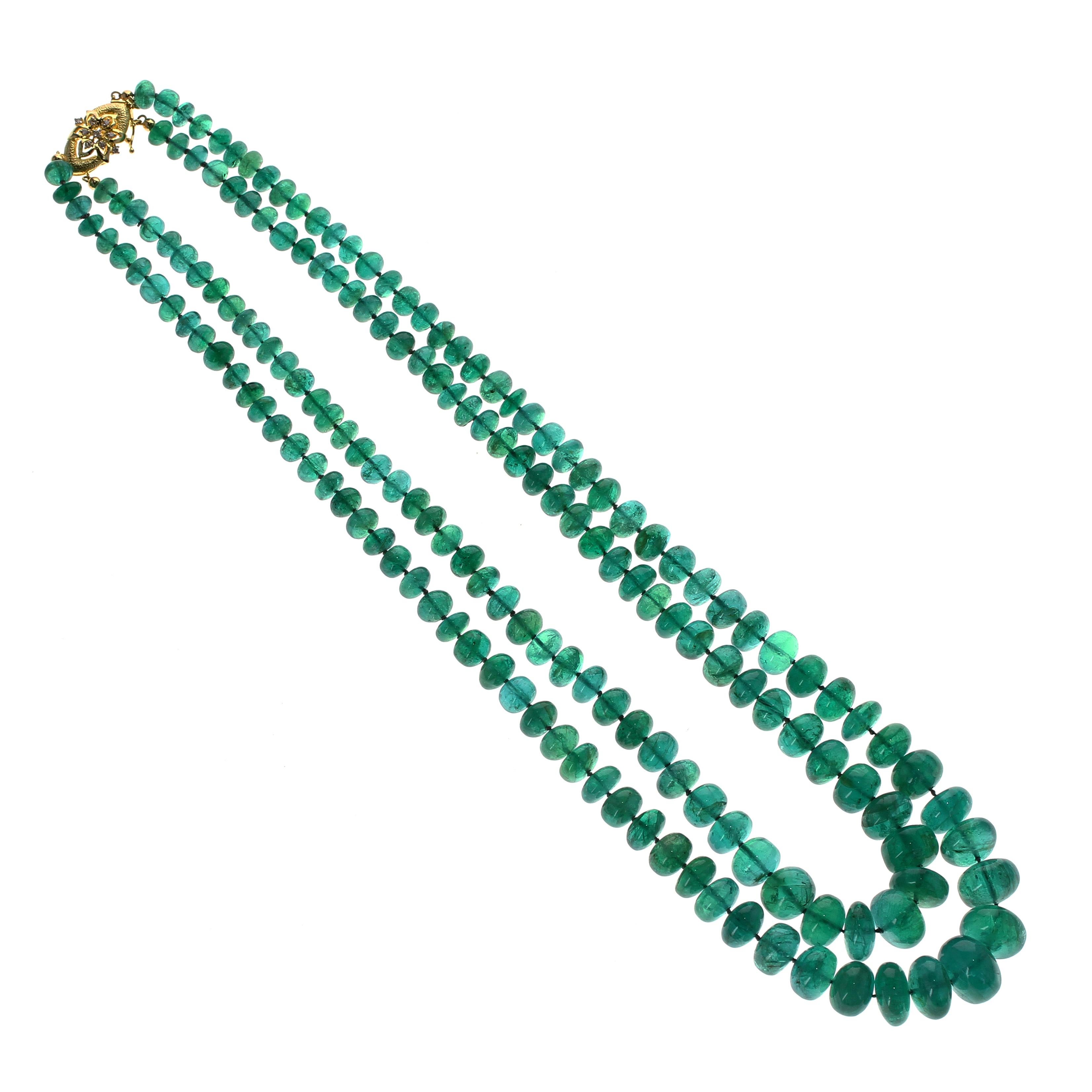 An impressive gemstone bead necklace strung with two rows of emeralds, measuring from 6.5 to 15 mm, and weighing approximately 645 carats (with clasp). The yellow gold clasp with diamonds is for presentation purposes only can be re-designed or