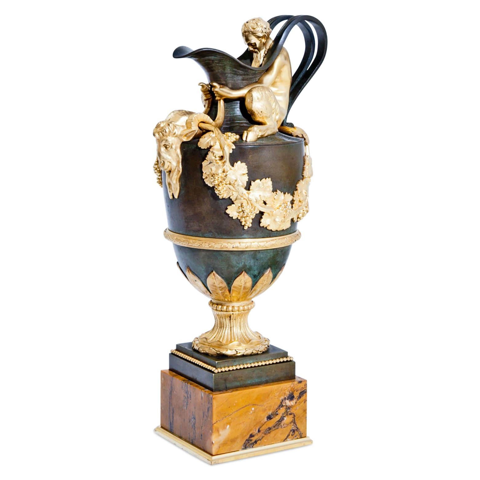 Pair of impressive jugs, standing on square bronze bases with firegilt pearl molding above square beige marble plinths. The bronzed jugs stand on a waisted round firegilt foot with laurel wreath and stylized leaf décor. The jugs have a classical