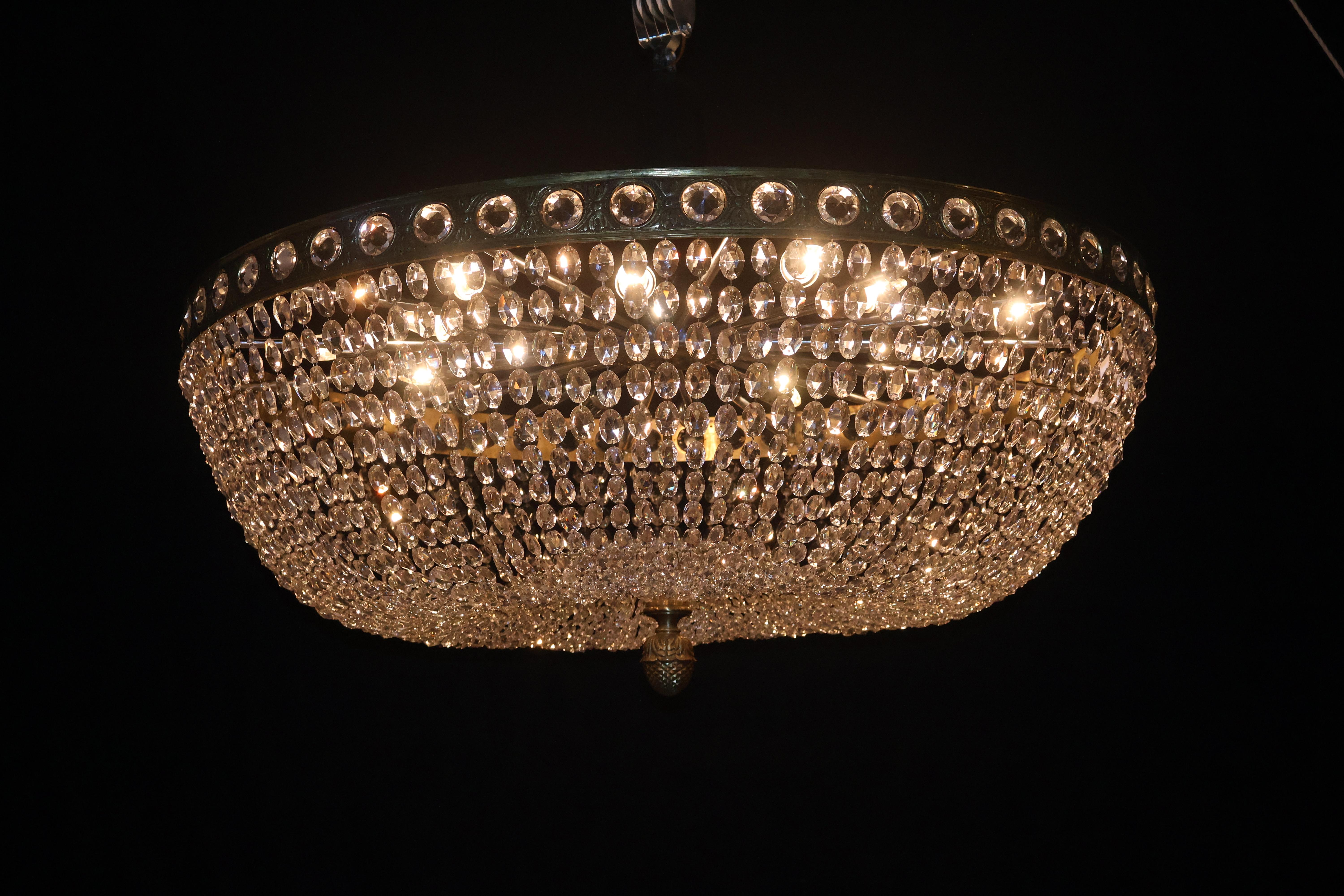 A Very Important Flush Mounted Chandelier. The main band fitted with round faceted jewels, issuing graduated chains of faceted oval beads. At the bottom a hand cut crystal plate & gilt bronze pineapple finial. (several identical fixtures available).