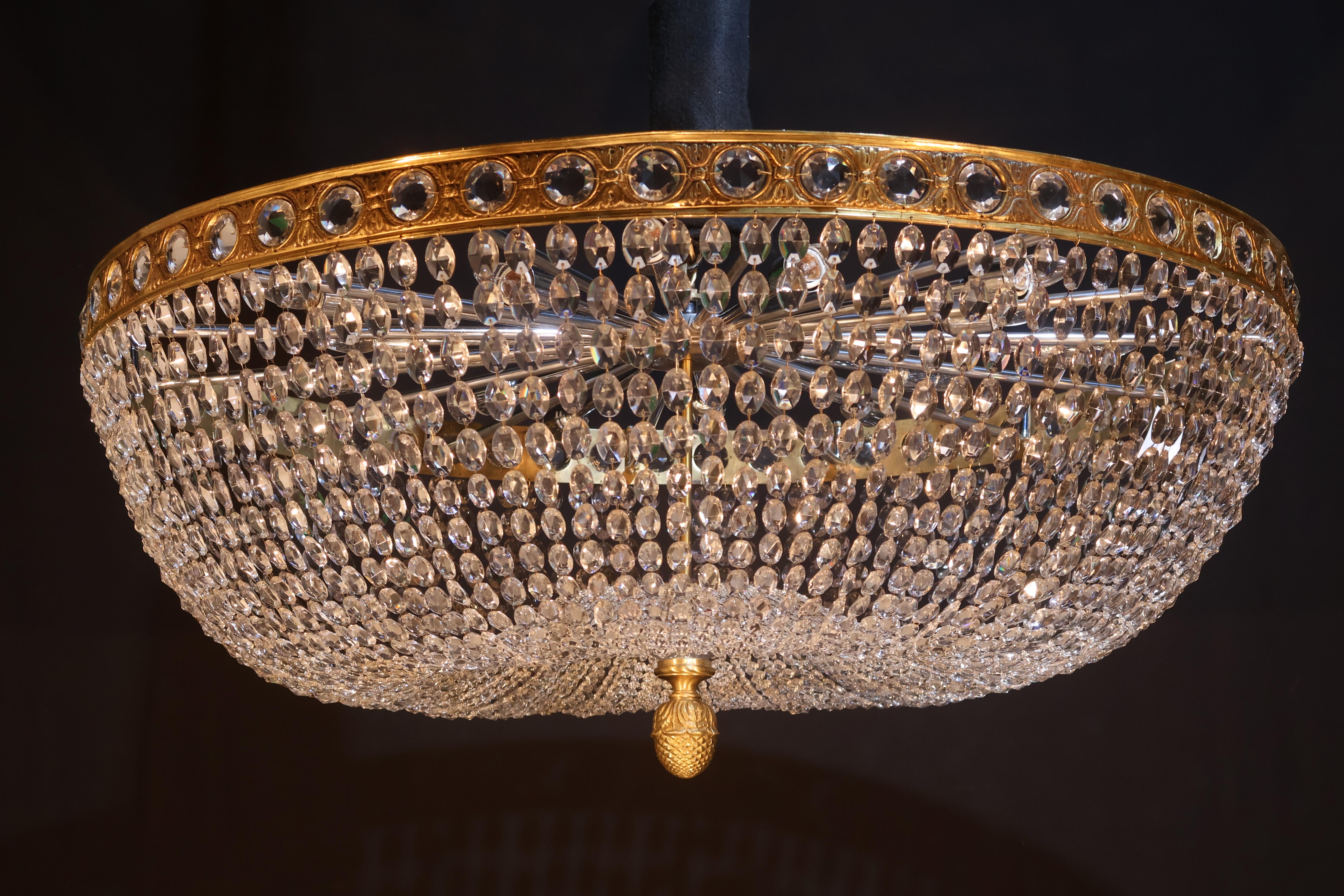 A Very Important Flush Mounted Chandelier. The main band fitted with round faceted jewels, issuing graduated chains of faceted oval beads. At the bottom a hand cut crystal plate & gilt bronze pineapple finial. (several identical fixtures available).