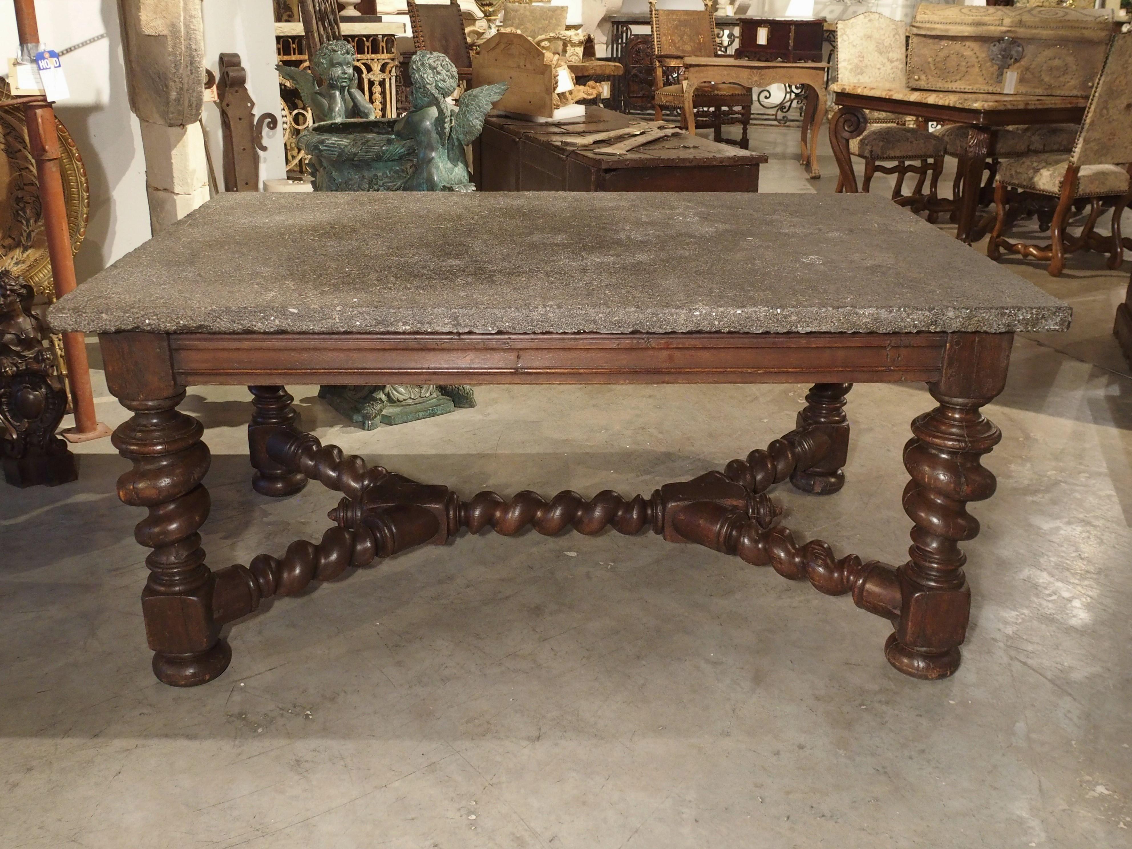 Hand-carved in France, this impressive oak table was produced in circa 1850. The fantastic table has large turned legs with a stretcher and is topped with a 1 ½ inch thick Belgian bluestone top.

The table apron is carved on all four sides, with a