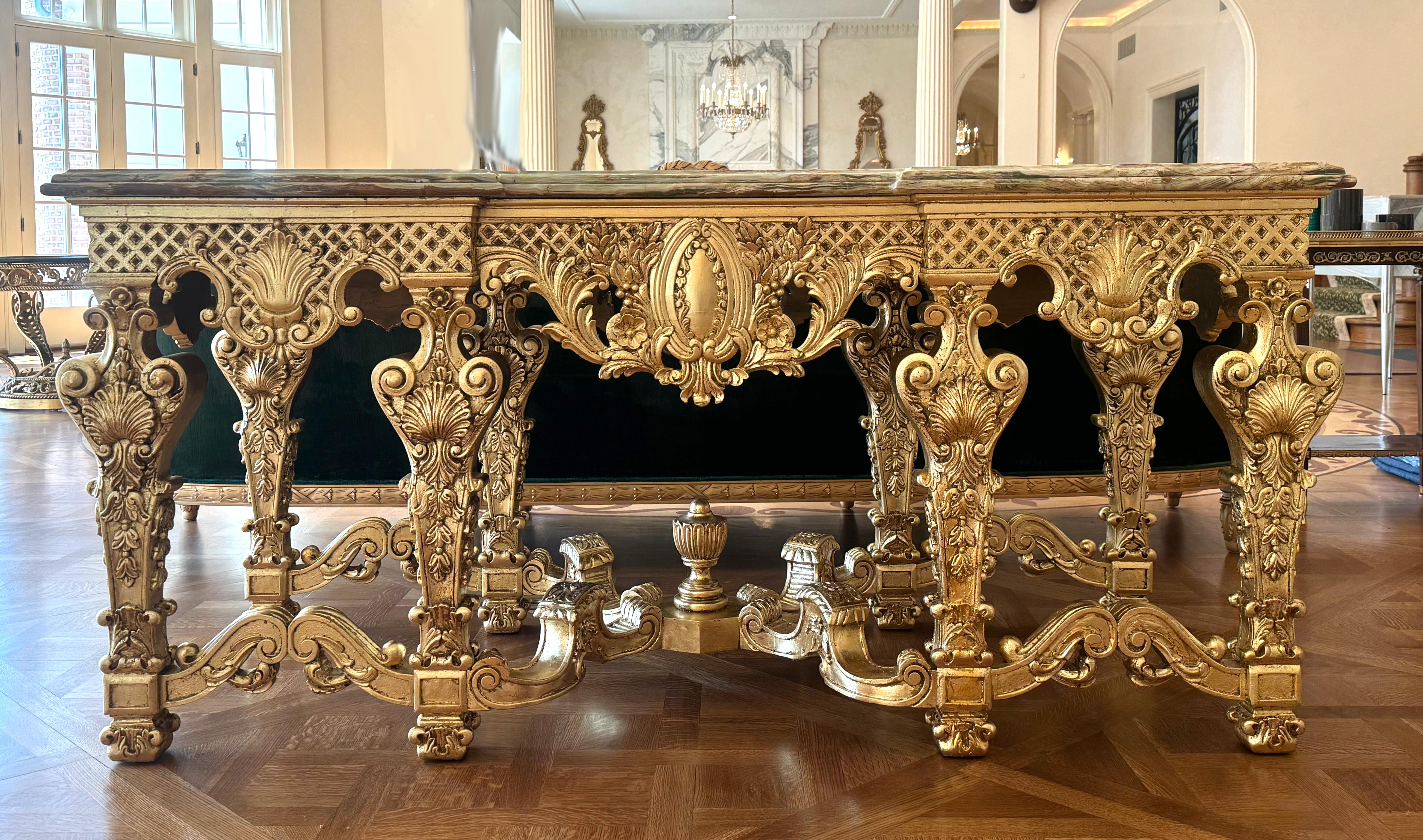 Impresionante Mesa de Centro de Madera Dorada con Tapa de Ónice Estilo Regencia Francesa (una de un par, ver lote siguiente)
La parte superior rectangular de ónice verde moldeado con moteado marrón y crema, sobre un friso tallado en todo el contorno