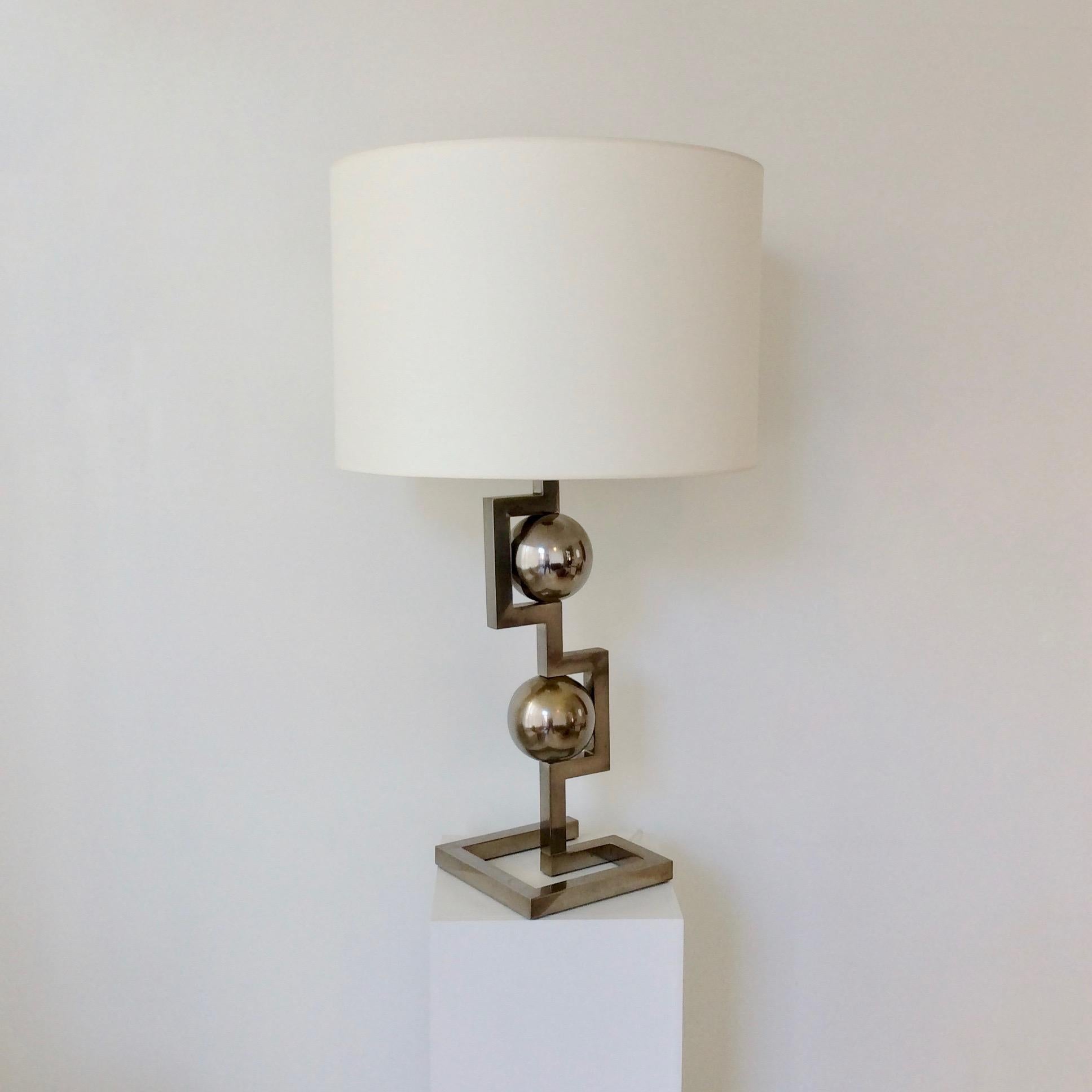 Impressive geometrical table lamp, circa 1970, Italy.
Nickelled metal. New fabric shade.
One E 27 bulb of 60 W.
Dimensions: 89 cm H, diameter of the shade: 52 cm, base: 22 x 22 cm.
Good condition.
Light wear consistent with age and use on the
