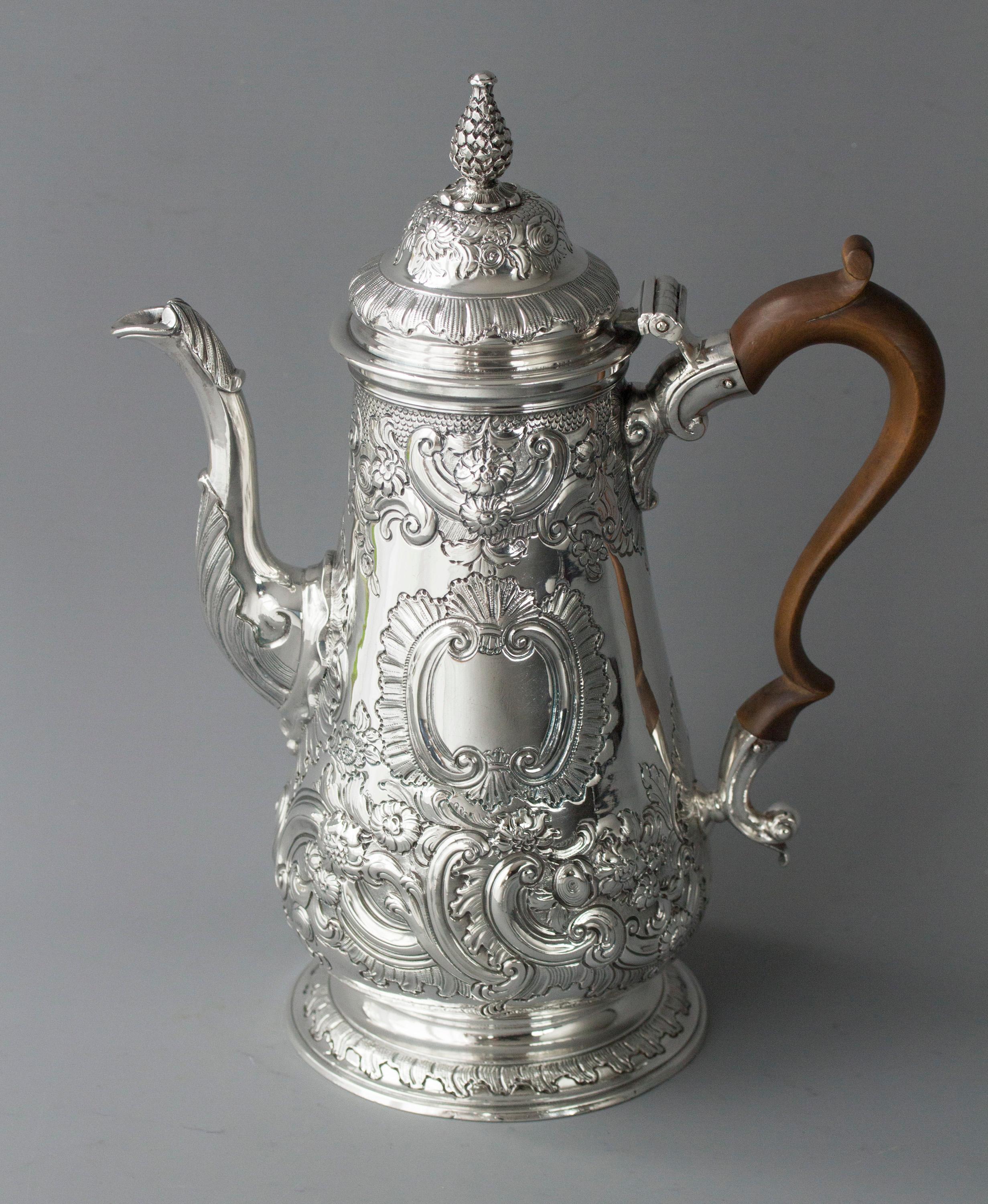 An impressive George II silver coffee pot of tapered baluster form, with a cast and applied spout, surmounted by a raised, domed lid with a cast pinecone finial. Original scroll fruitwood handle. All standing on a raised circular foot. The pot is