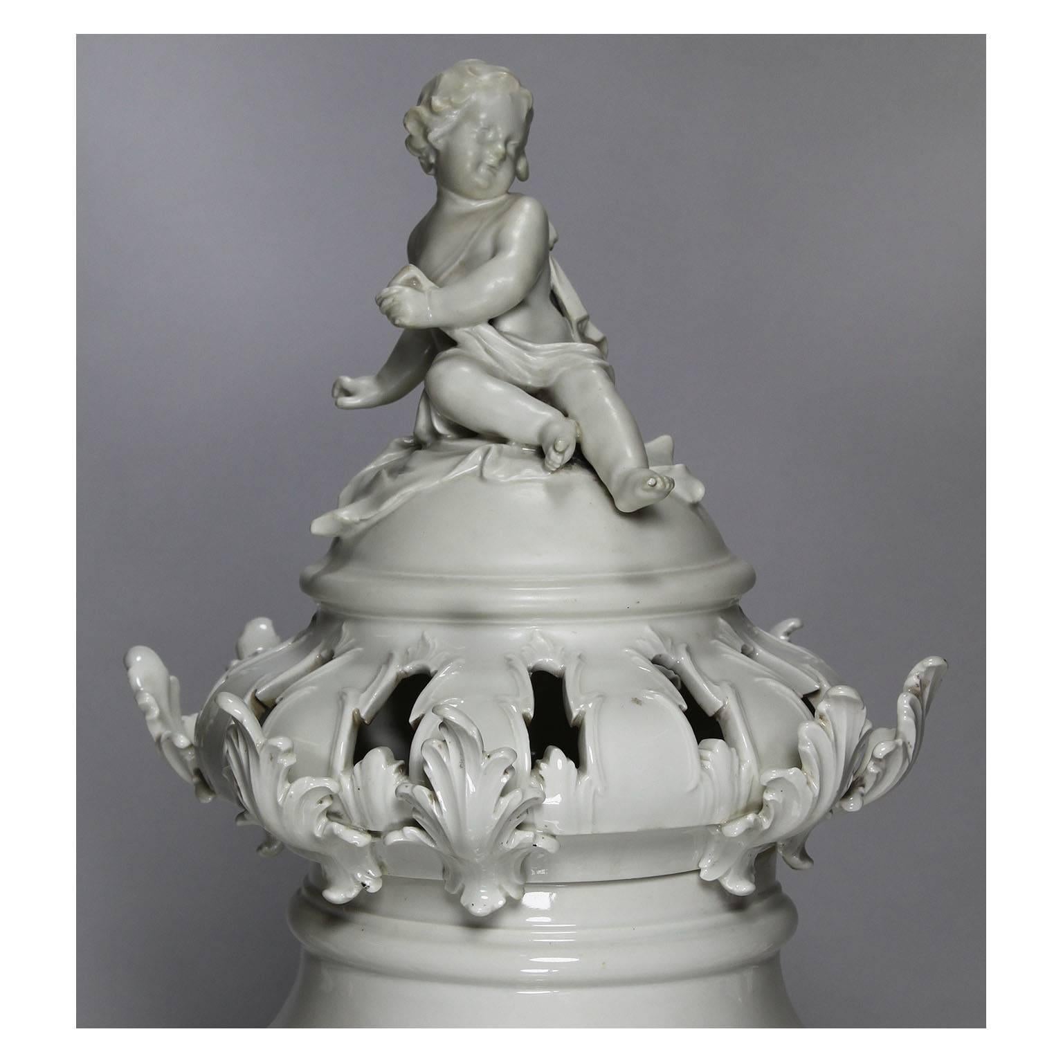 A large and impressive German 19th century Rococo Revival style Berlin KPM porcelain figural exhibition urn vase with cover. The ornately decorated ovoid and rotating white porcelain body in the form of acanthus, rocaille, foliate and ribbons