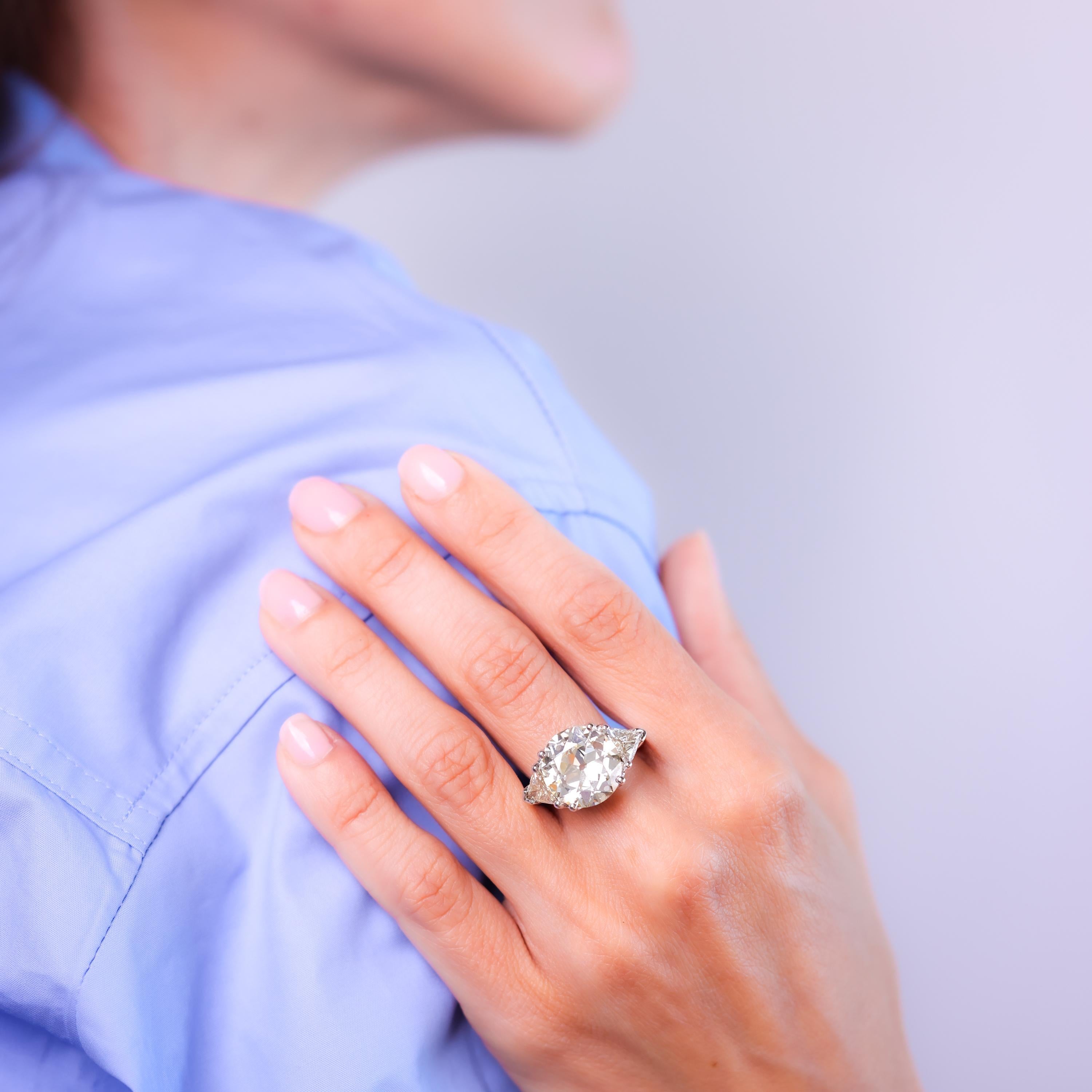 Certificate: GIA #5231416391
Center stone: Old European cut diamond 
Weight: 8.16 Carat
Color: Q-R
Clarity: SI1
Accent stone: 2 triangle cut diamonds 
Weight: Approximately 1.2 carats
Color: O-P
Clarity: VS
Metal: 18k white gold 
Era: Vintage
