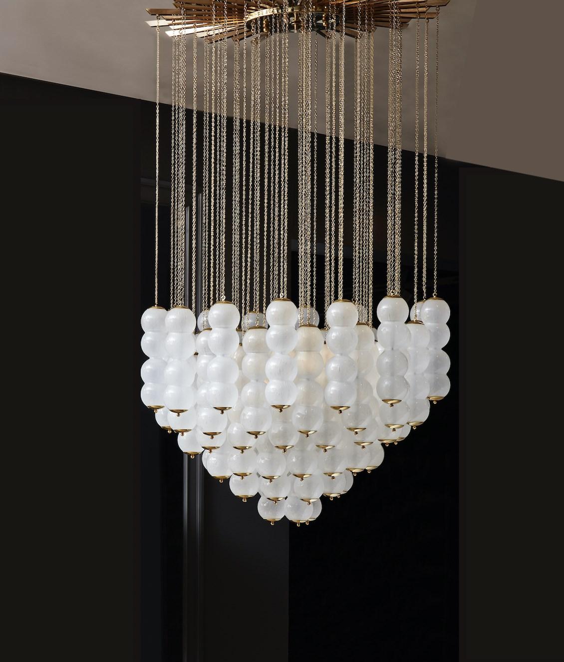 Questo grande lampadario è sospeso su una struttura a forma di sole in ottone, con ciotole in vetro di Murano. Questo lampadario è illuminato da otto lampadine.
Création Studio A Glustin.