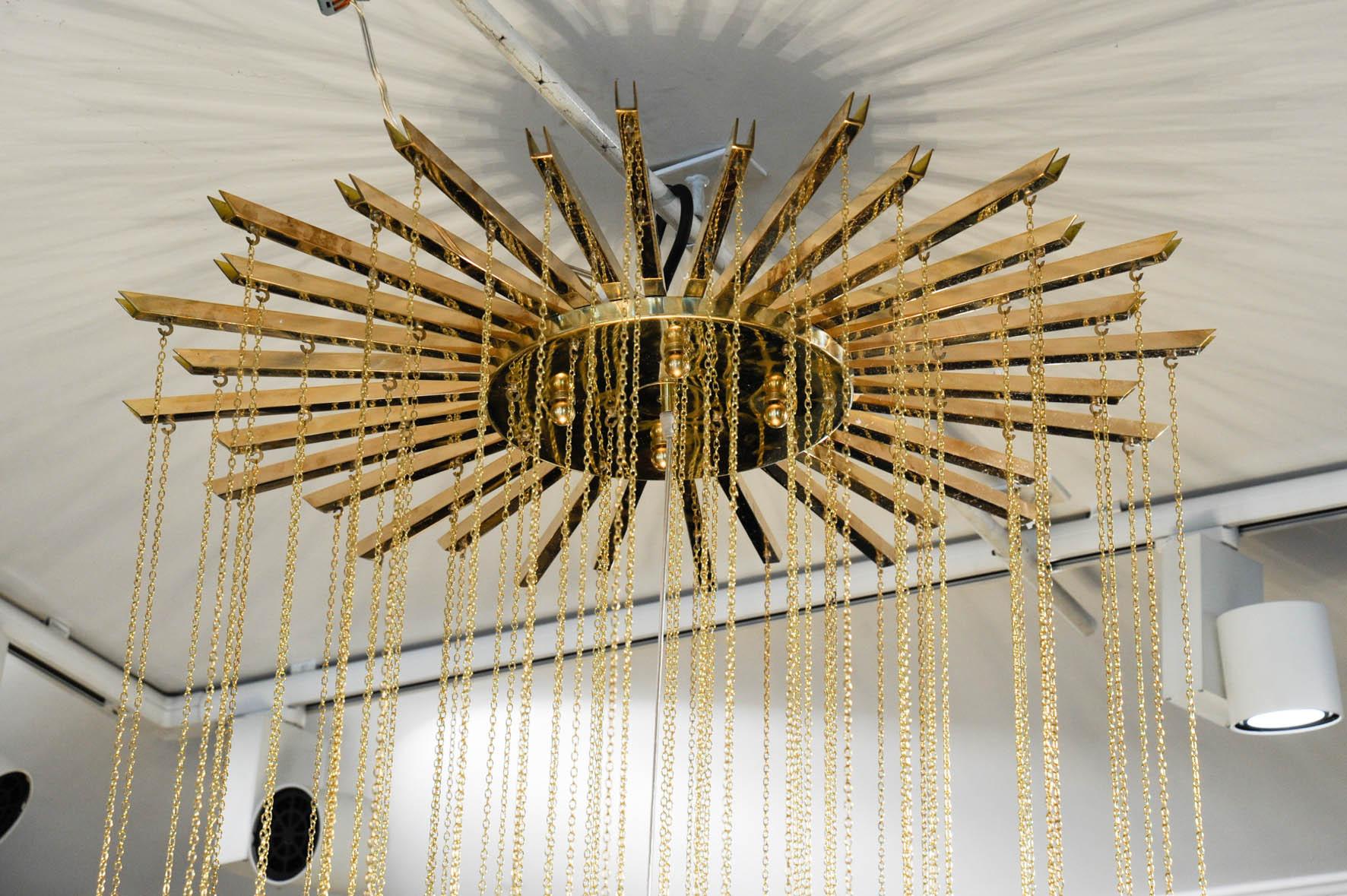 This great chandelier is suspended on a sun shaped structure in brass, with Murano glass bowls. Eight-light bulbs are lighting this chandelier.