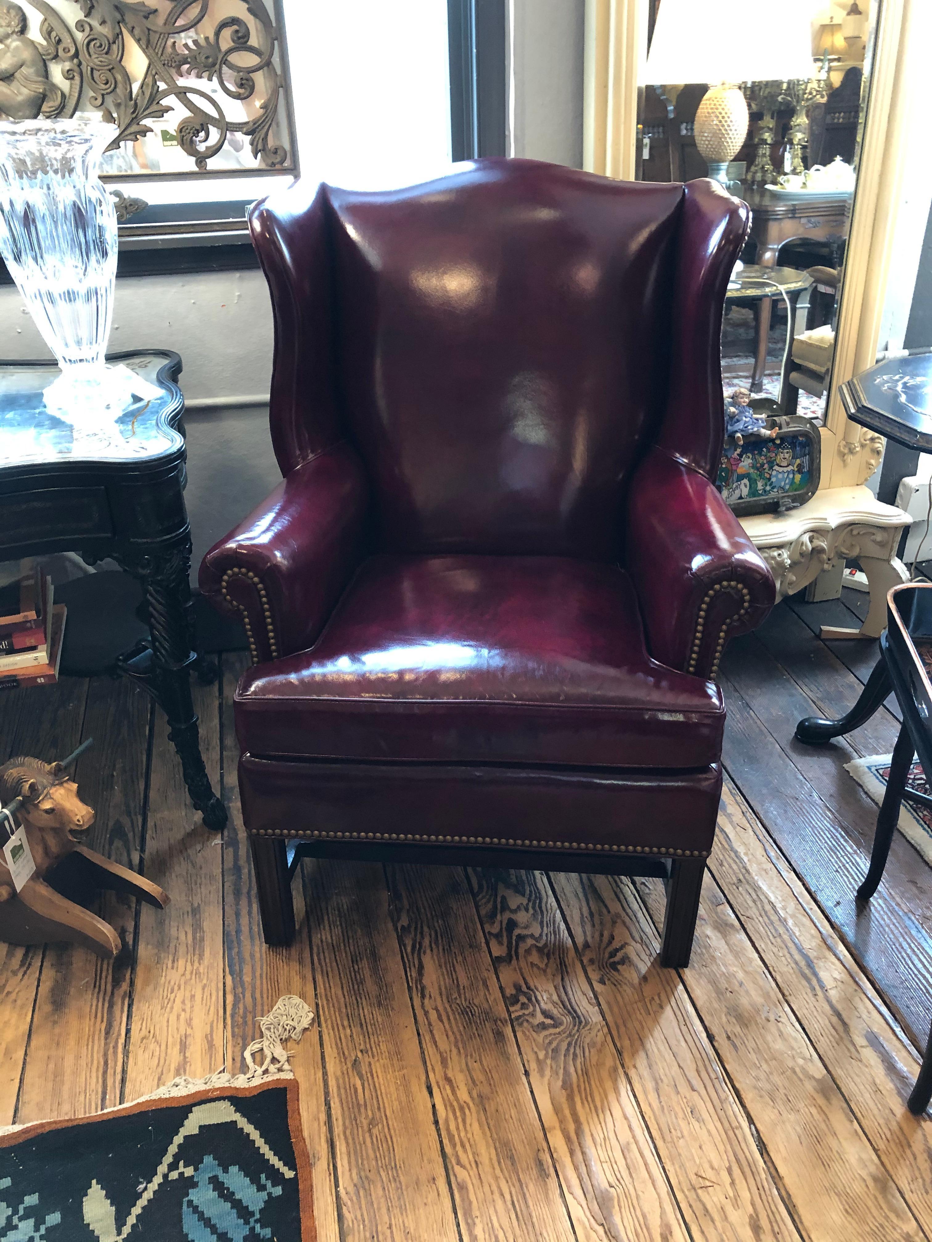 Impressive very comfortable pair of designer Hancock & Moore leather wing chairs in a perfect medium scale, having striking rich cranberry color and brass nailheads. Beautiful from every angle. 
Measures: seat 20 h
Arm h.
 