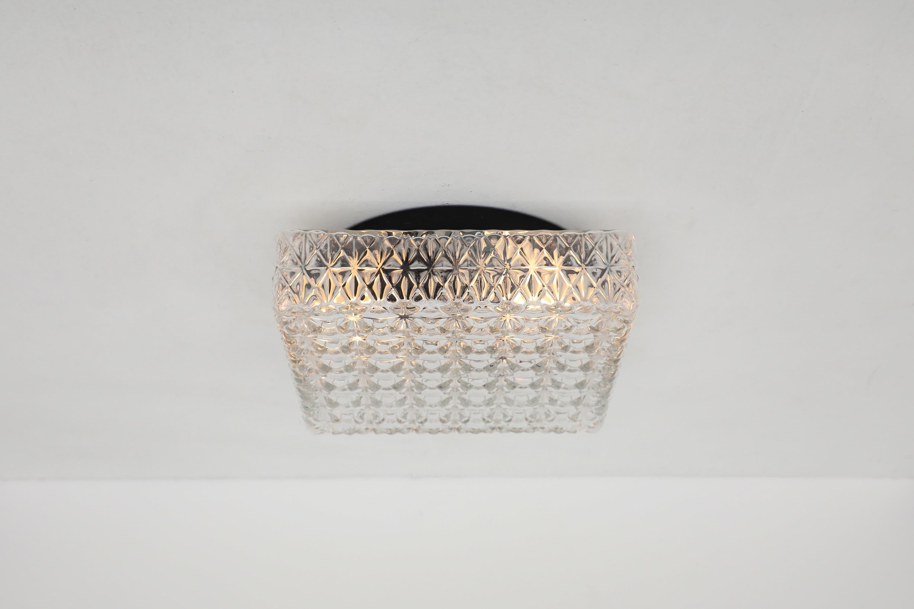 Stunning heavy square Mid-Century textured glass ceiling sconce. In original condition with visible wear consistent with its age and use.This lamp is hardwired and takes a medium base E26/E27 bulb. Many other similar sconces are available in
