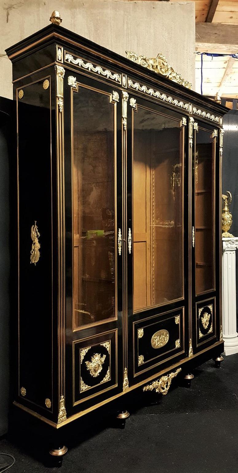 Impressive Hercules huge Bookcase vitrine Napoléon III with 3 doors in Boulle style Marquetry.
Blackened wood with very Rich ornamentation of gilt bronze with motifs of foliage, 2 Hercule masks, (symbol of Strength) on both doors, and an oval