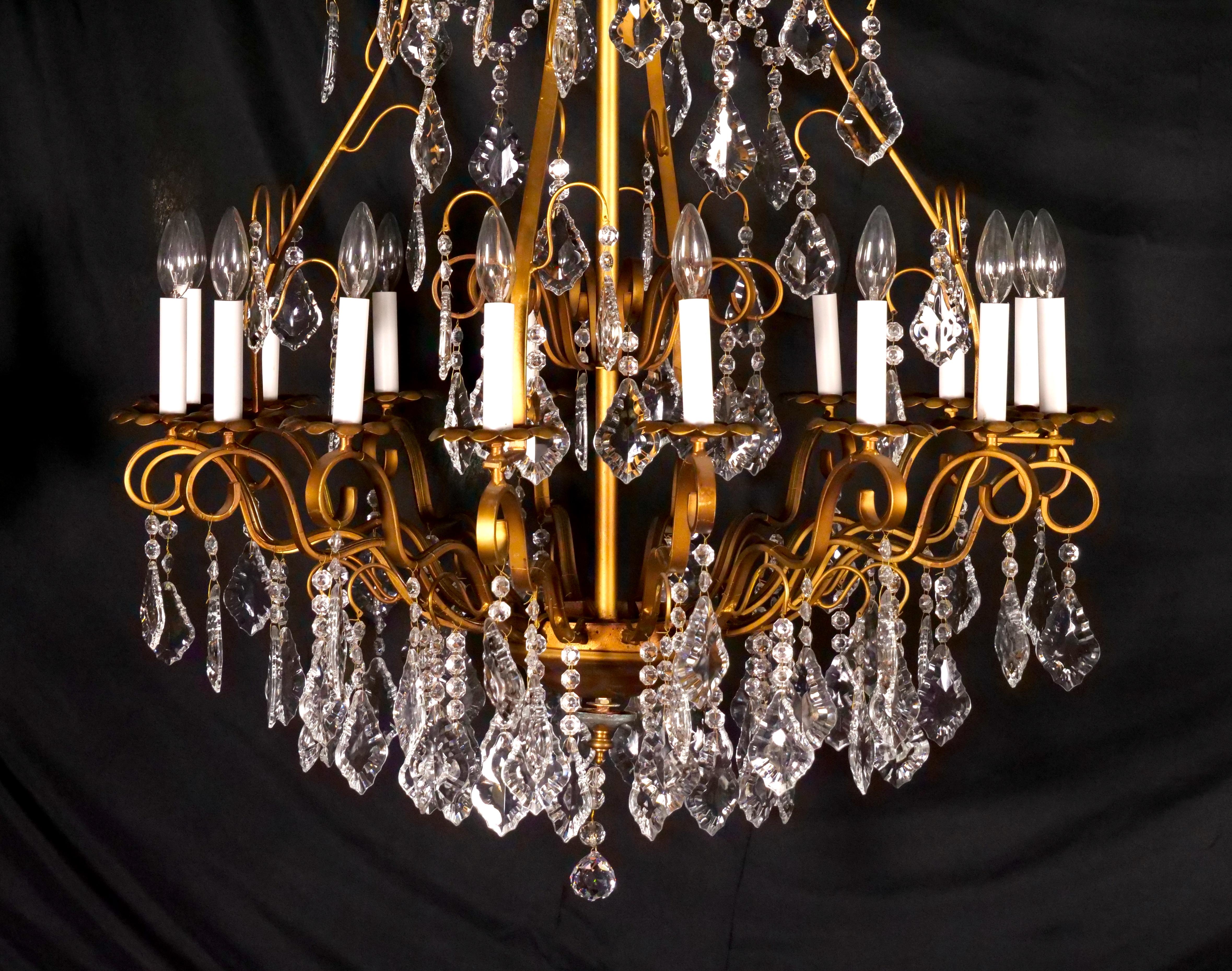 Erhöhen Sie Ihren Raum mit der Grandeur dieses beeindruckenden italienischen Kronleuchters aus dem frühen 20. Jahrhundert mit vergoldetem Messingrahmen und sechzehn Lichtern aus geschliffenem Kristall. Dieser Kronleuchter ist ein großartiges