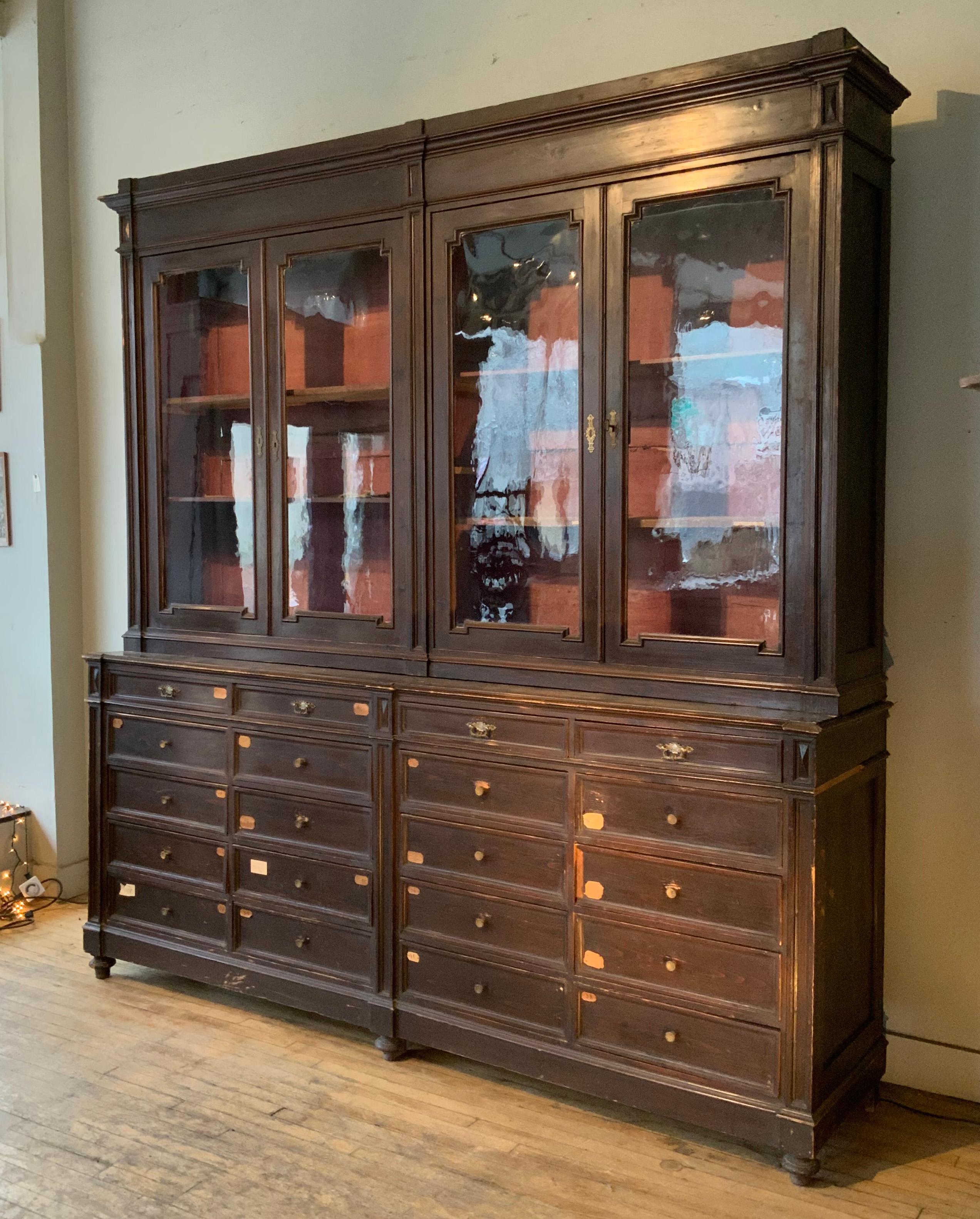 an incredible mid-19th century large Italian mercantile cabinet, with a base of four banks of 20 deep drawers, and an upper cabinet with shelves, and its original antique glass doors along with the original keys. wonderful scale and details. large
