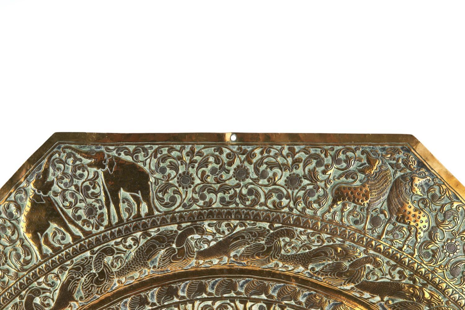 This is an impressive large late 19th Century antique brass charger, which is octagonal in shape and having marvellous ornate decoration of various animals and creatures amongst scroll work.