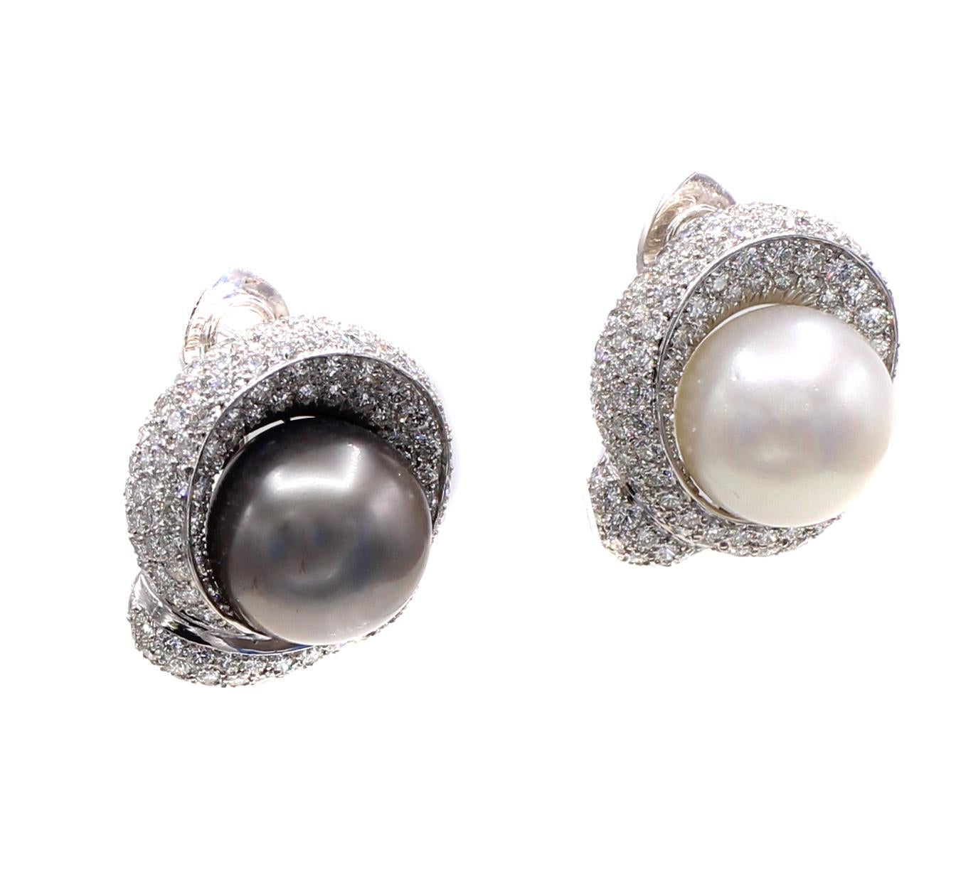 Beautifully designed and masterfully handcrafted these platinum stylish and chic ear clips feature a natural black and white south sea pearl measuring approximately 16 millimeters each. Both pearls show a wonderful luster and shape. Surrounding them