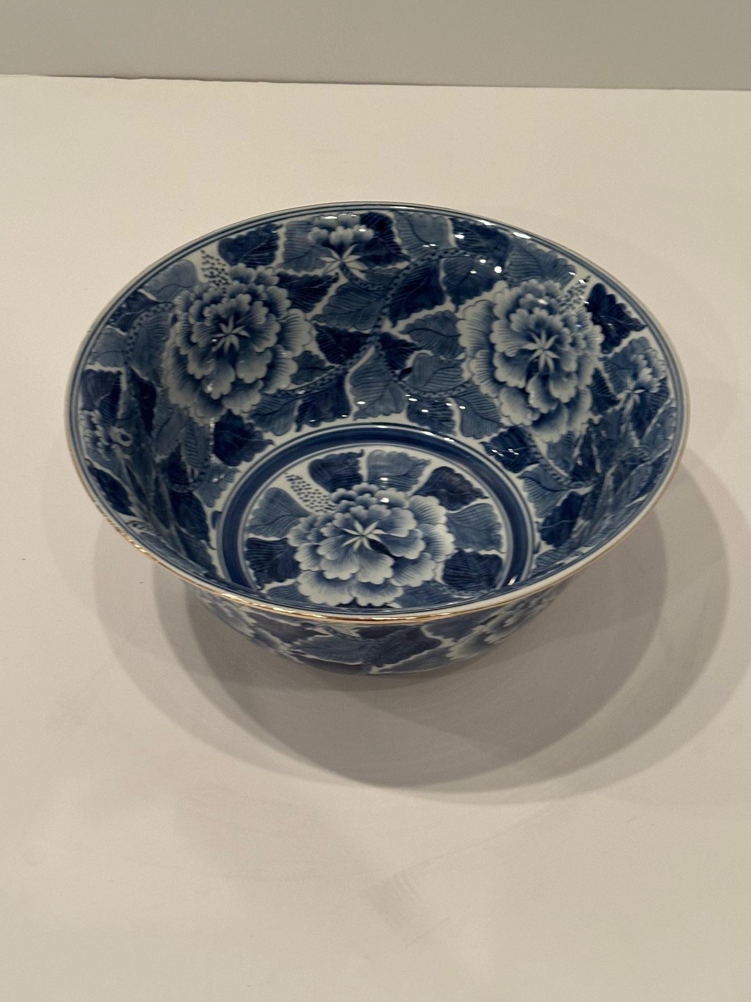 Schöne antike chinesische Porzellanschale mit ausdrucksstarkem, blau-weißem, handgemaltem Blumendekor und Messingakzenten oben und unten.