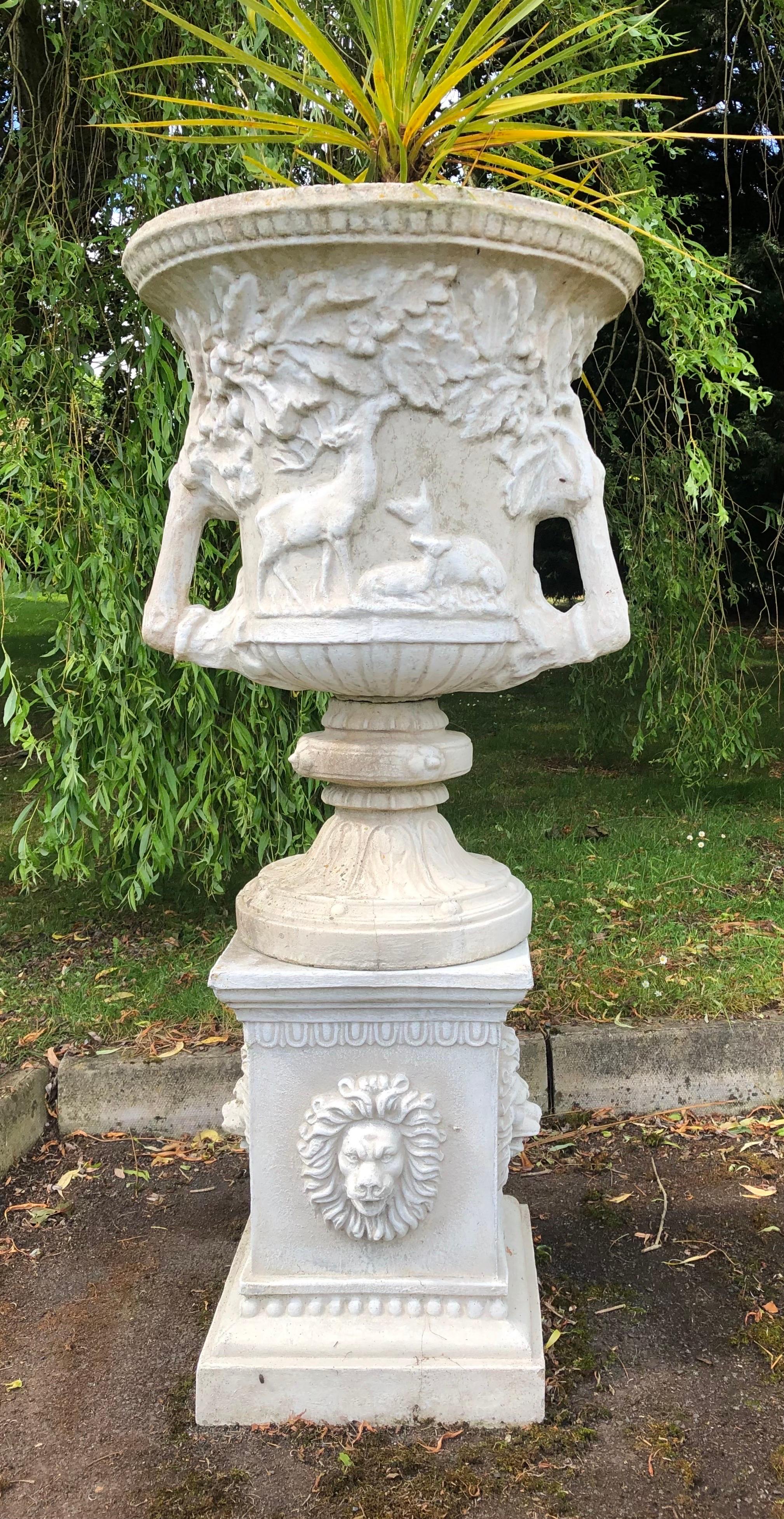 Une impressionnante urne de style classique.

L'urne est ornée de cerfs moulés sur tout son pourtour. Poignées lourdes de chaque côté. 

L'urne repose sur un socle à douille, qui lui-même repose sur un lourd piédestal carré. La base est ornée de