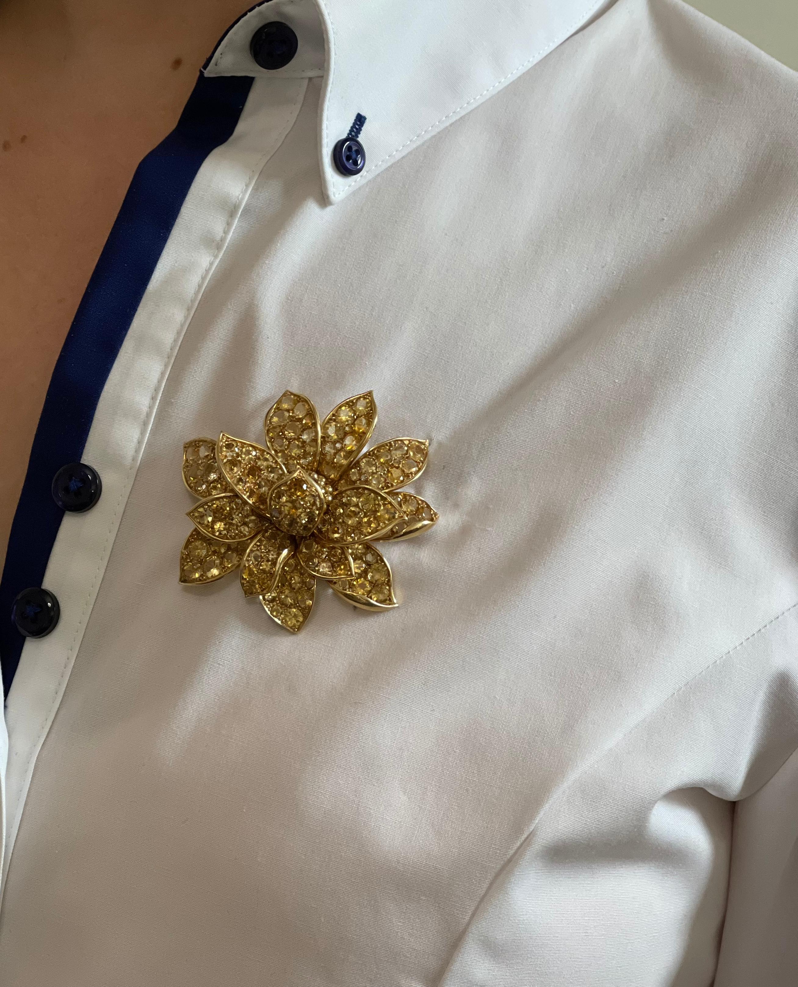 Large 18k yellow gold flower brooch, with round cut vivid yellow sapphires. Brooch possibly made by Rene Boivin, bears punchmarks on the stem. Brooch measures 2.25