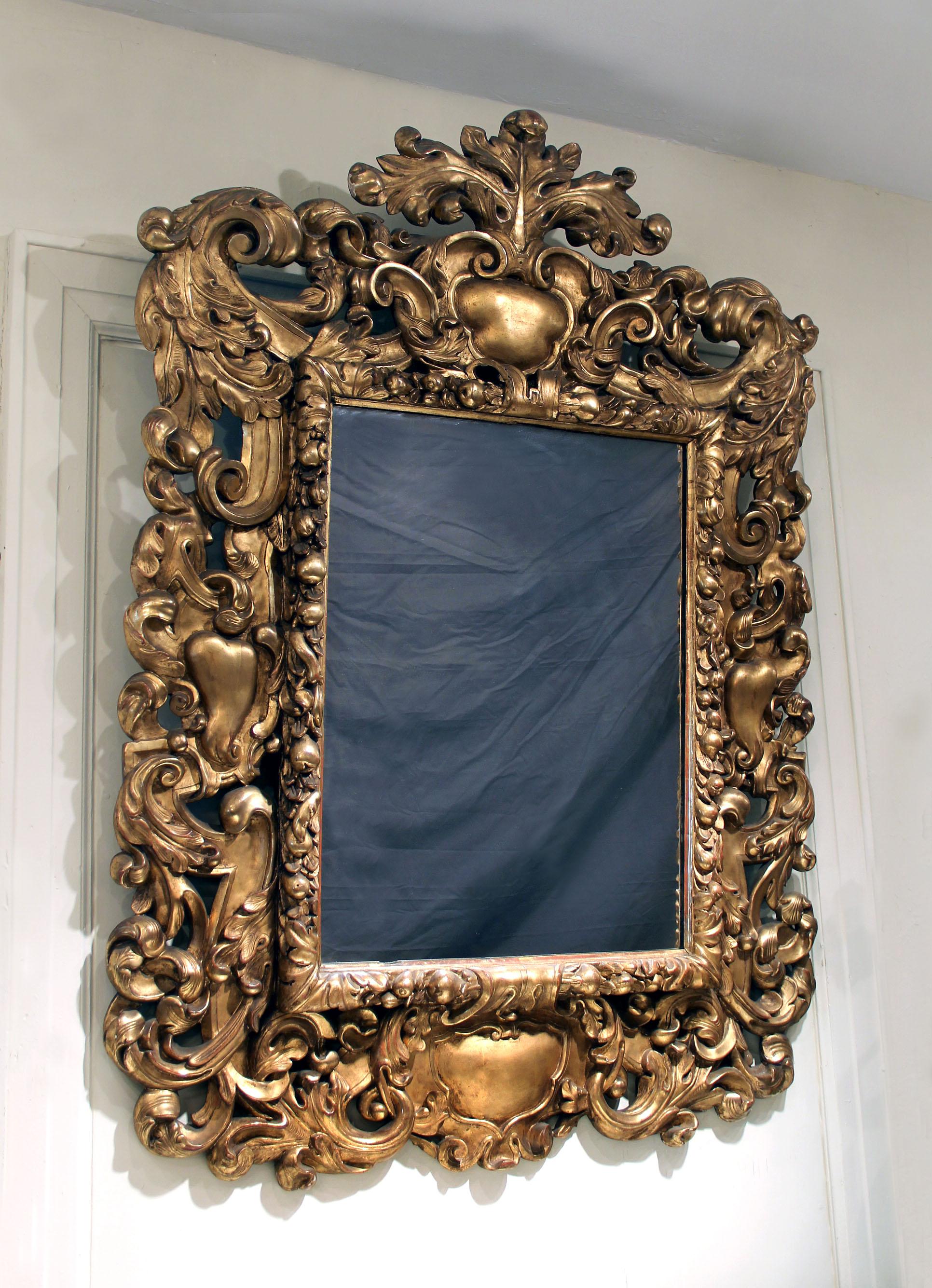 An Impressive Late 19th Century Carved Giltwood Rococo Style Mirror

The large and wonderfully carved rectangular mirror surrounded with sprawling acanthus leaves, the inset part of the frame with carved fruits and flowers, the central top designed