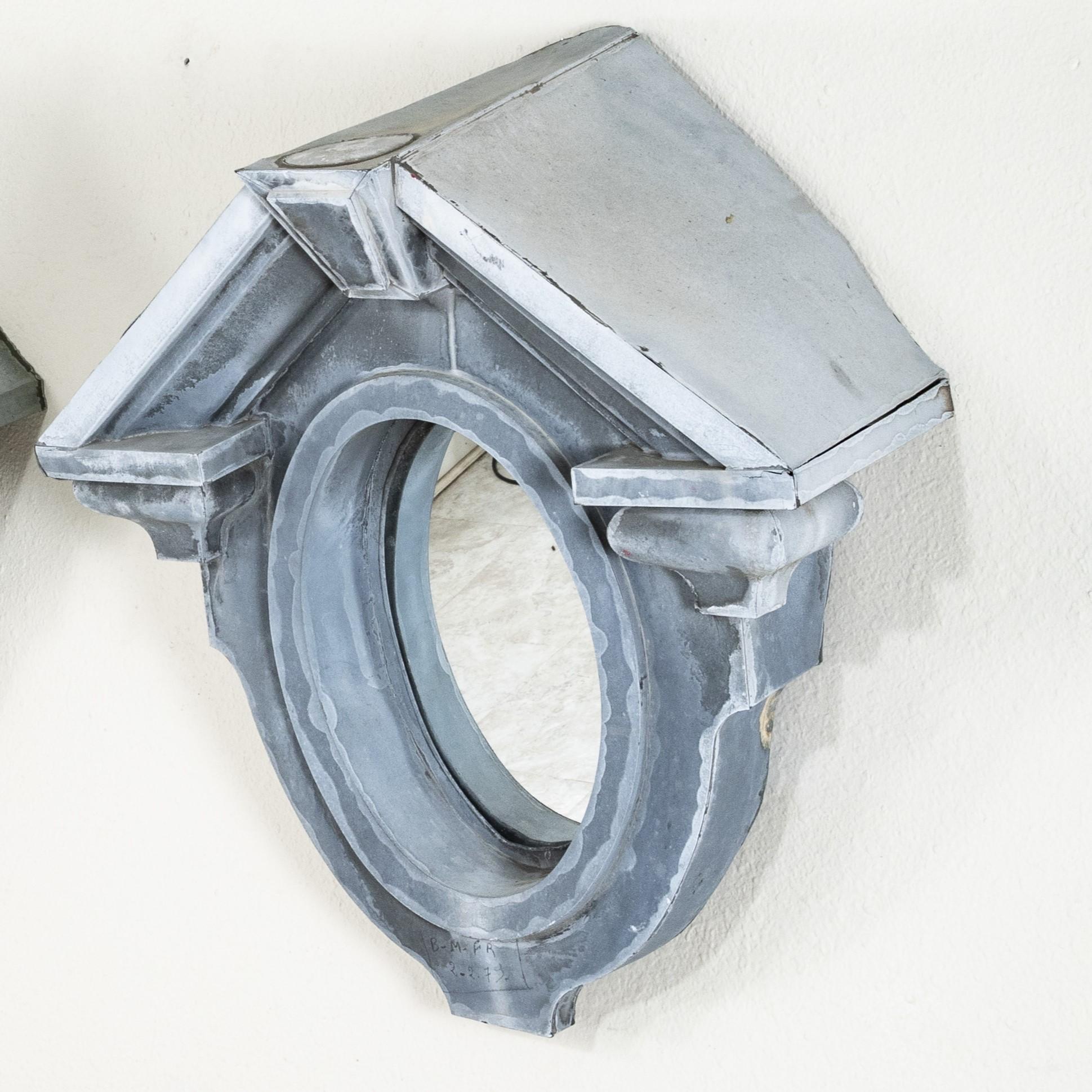 This nineteenth century zinc bull's eye window, called an Oeil de Boeuf in French, was originally a dormer window in a mansard roof of a Normandy manor house. At 34 inches in height, with its classic pediment style roof and interior mirror, this