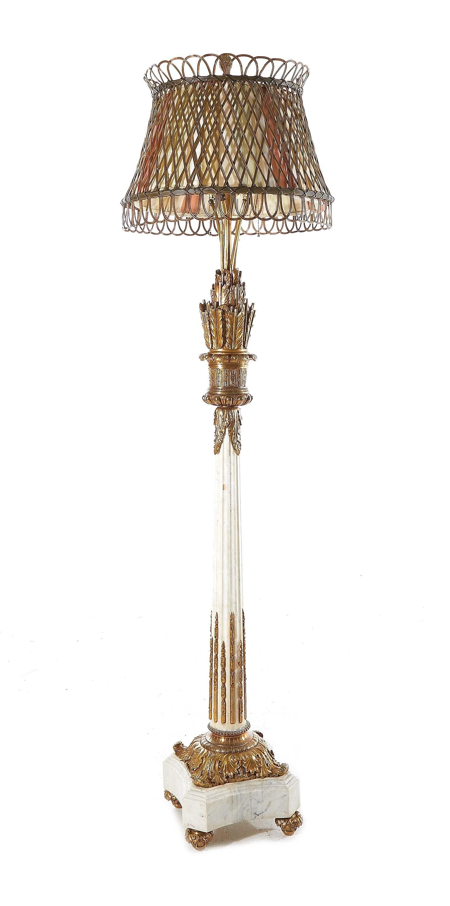 Beeindruckende Stehlampe im Louis XVI-Stil aus vergoldeter Bronze und Marmor, durchbrochener Bronzeschirm mit Stoffbespannung; getragen von einem Schaft mit Federkiel und Pfeil, kannelierter Säule und vierblättrigem Sockel, mit Bronzebeschlägen.