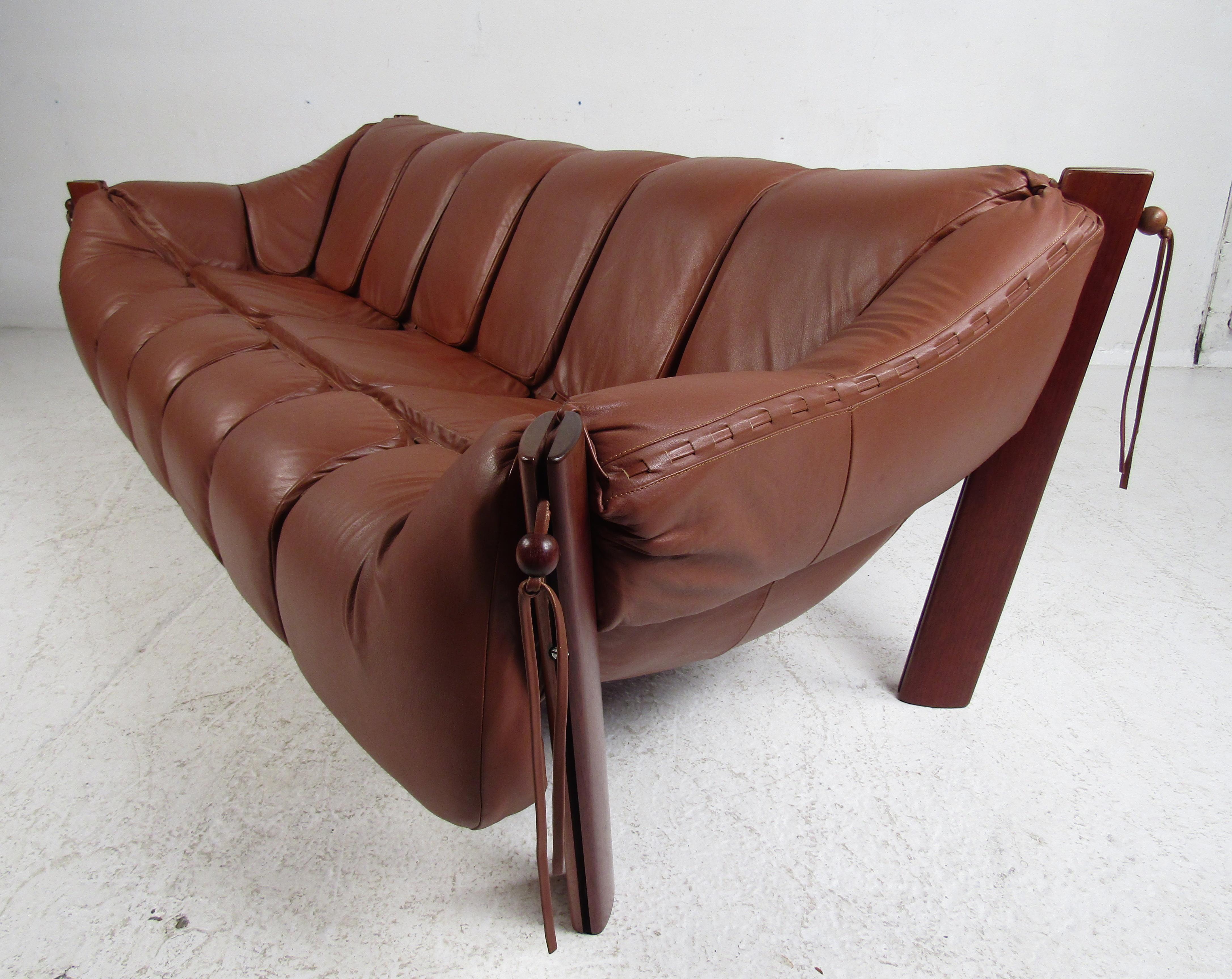 Dieses beeindruckende brasilianische Vintage-Wohnzimmer-Set besteht aus zwei Sesseln mit Ottomane und einem Sofa. Das gepolsterte Dreisitzer-Sofa und die Loungesessel sind mit Lederschnüren verziert:: die mit einer einzigartigen Perle aus Rosenholz