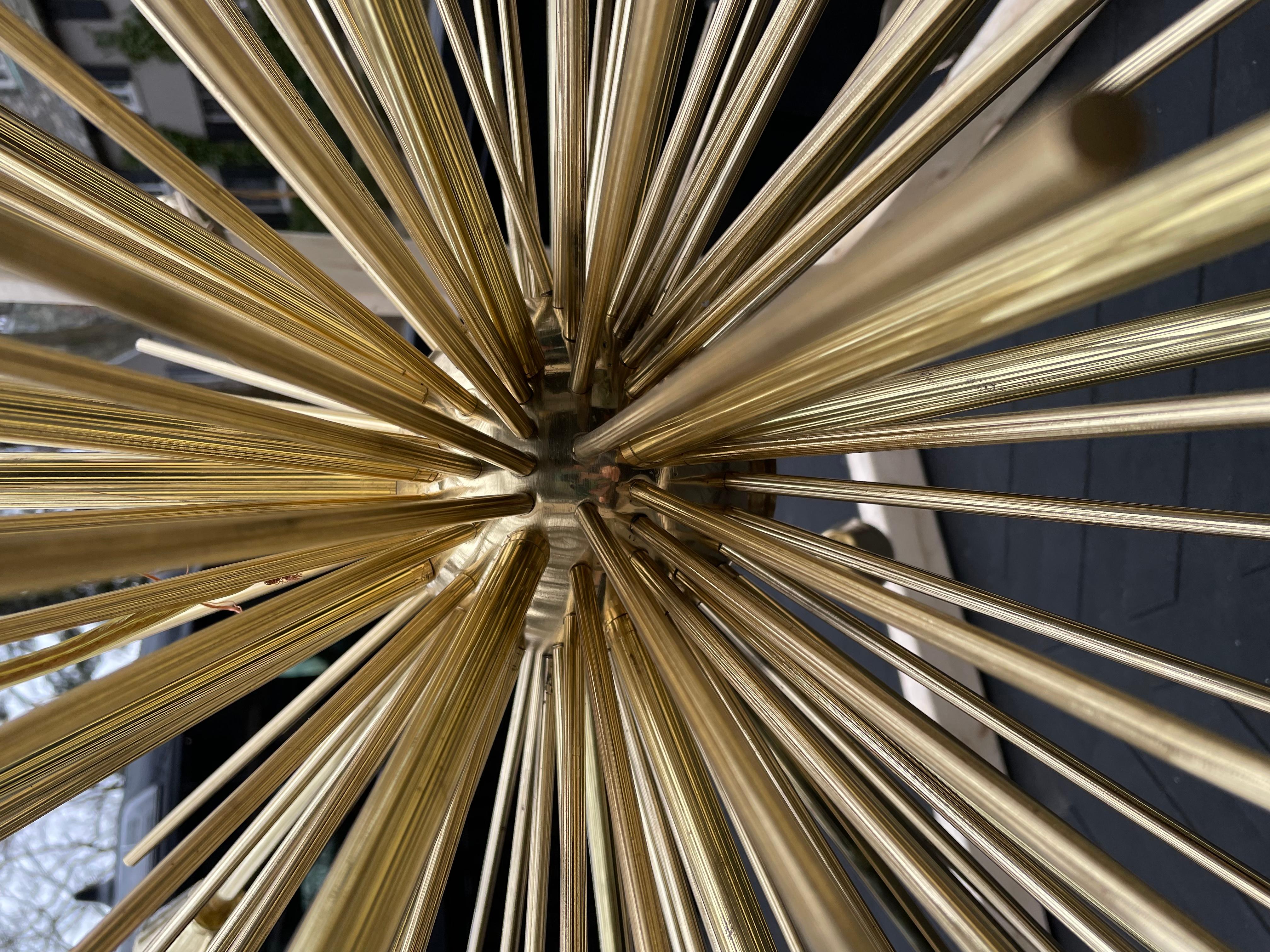 A fabulous 25 socket mid century brass Sputnik chandelier having completely rewired sockets, cleaned, polished and lacquered. It is photographed in a wooden frame that was built for transport. The vertical pole and canopy measure 20