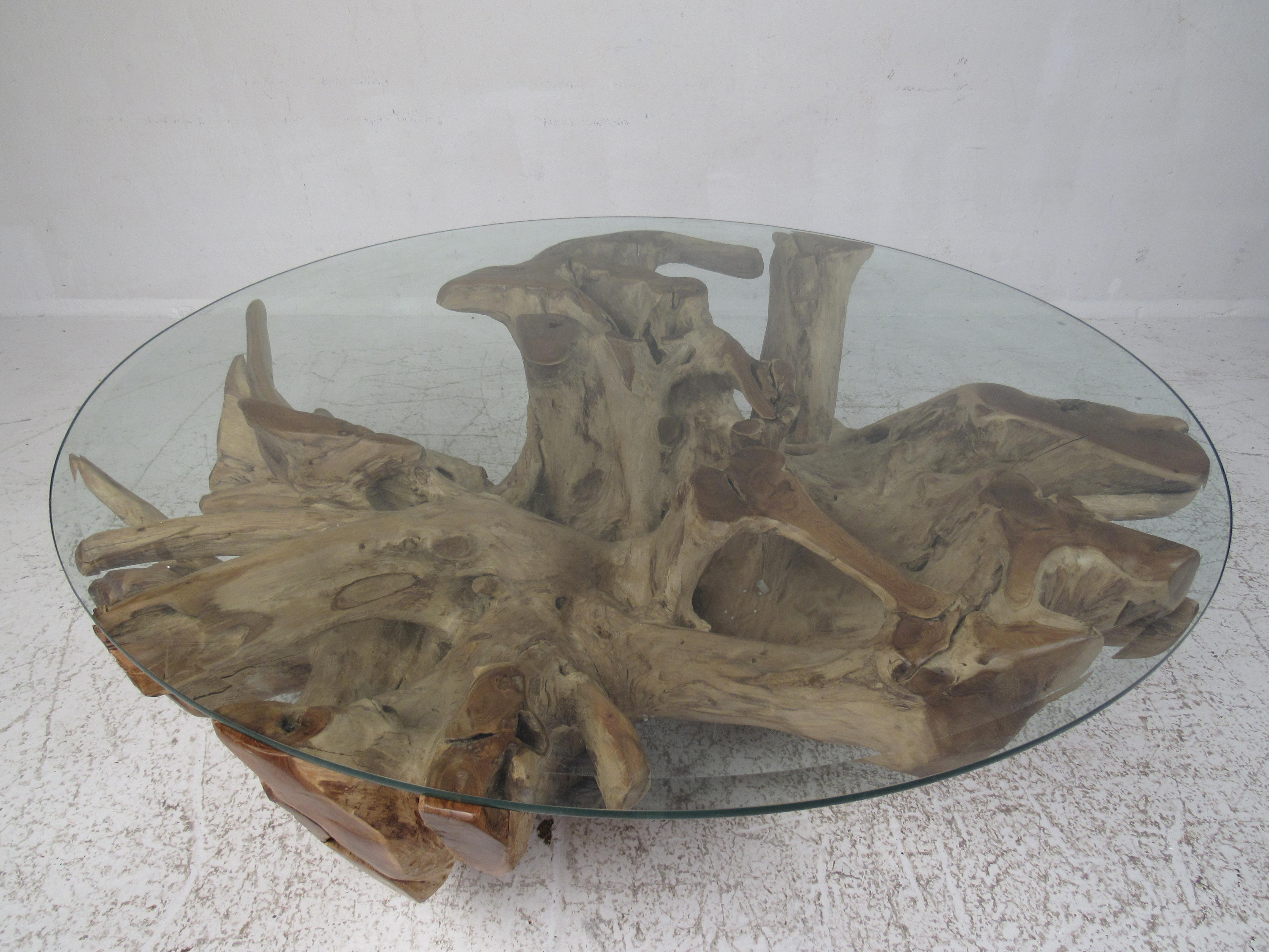 This beautiful vintage coffee table features an extremely heavy tree root base and a circular glass top with beveled edges. A real live edge wood coffee table that is sure to make an impression on any guest. An exquisite design that allows the thick