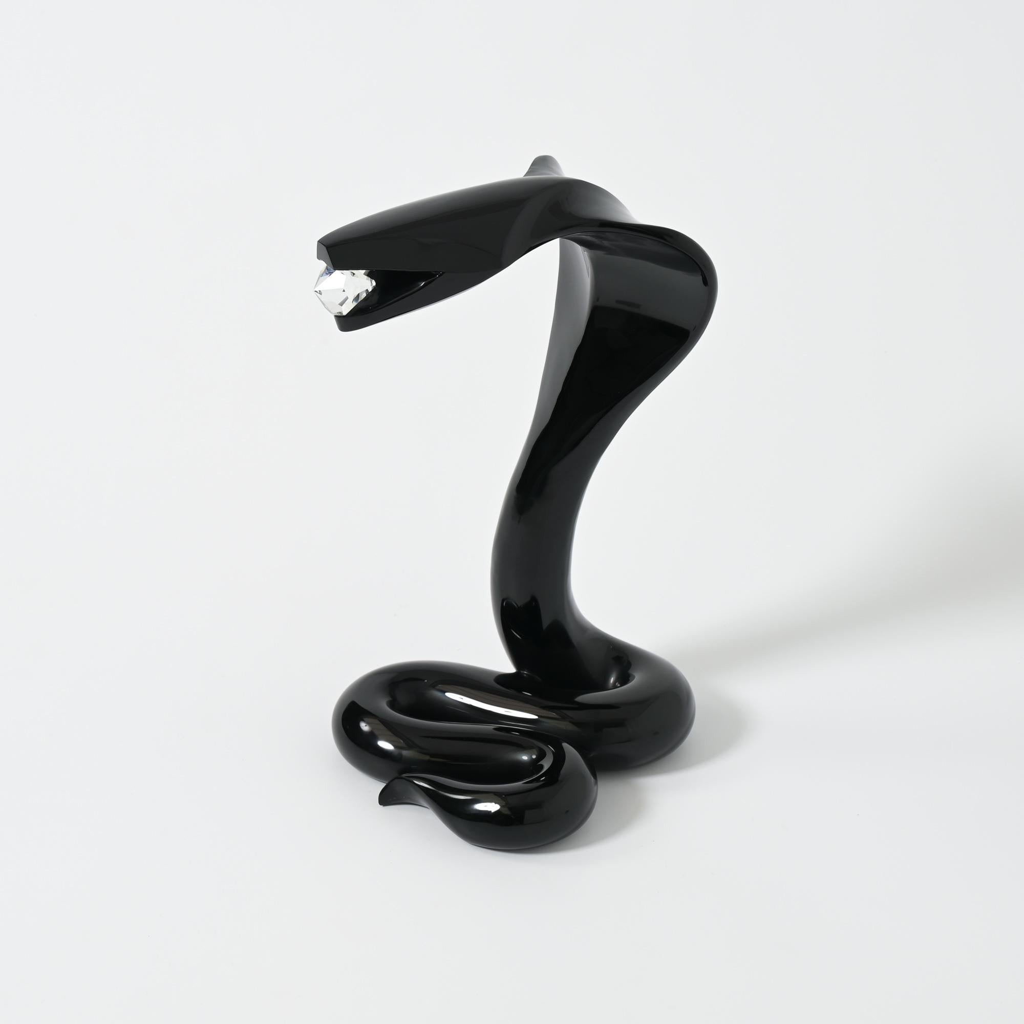 This Cobra sculpture was created and made by the famous Italian glass artist Loredano Rosin in his workshop in Murano, Venice, Italy in the 1980s.
The black Murano glass cobra holds a clear Murano glass diamond.
It is an impressive sculpture in