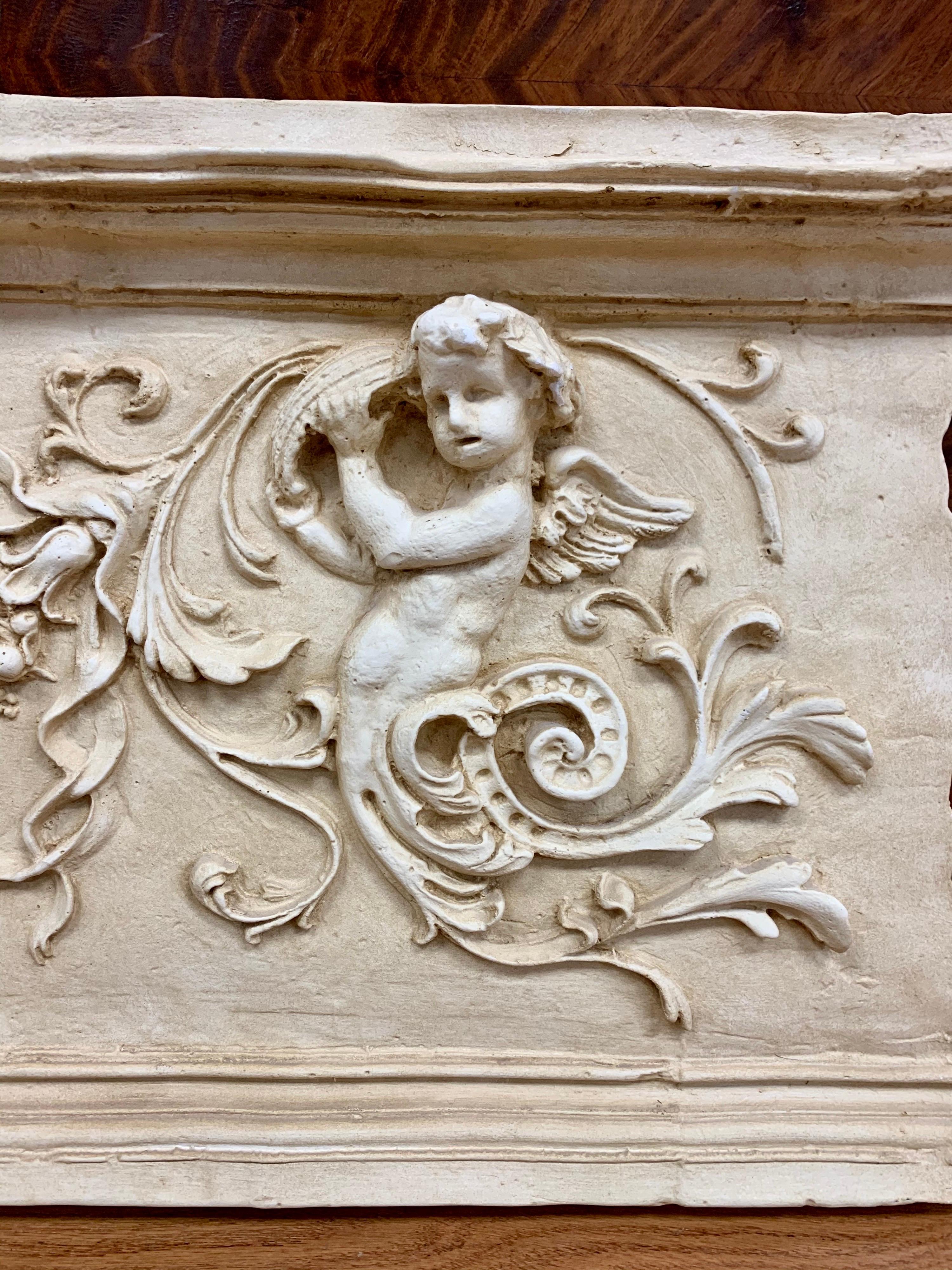 A very large reproduction of an architectural carved stone relief plaque. Features a highly detailed center fruit motif flanked my cherubs. Looks and feels like actual stone until you pick it up. Lightweight and is ready to hang on any wall.