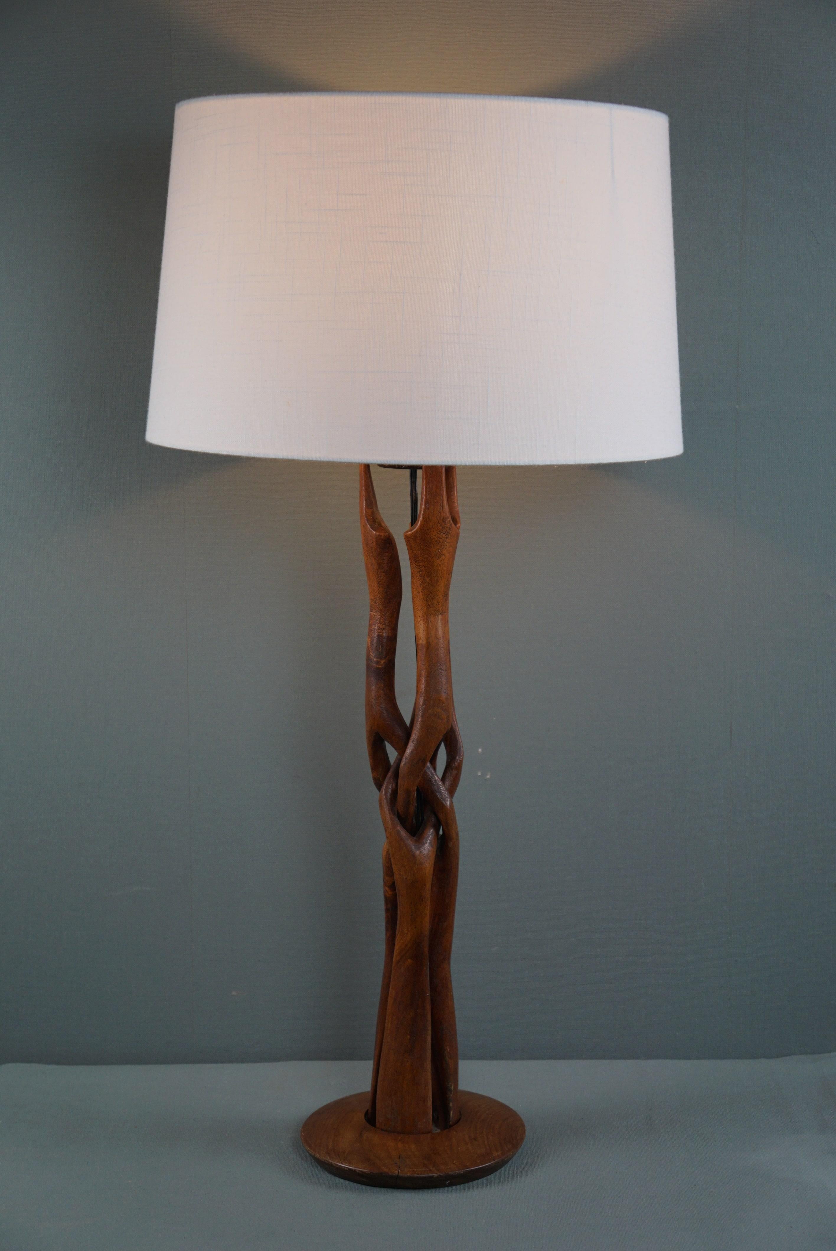 Offered is this impressive wooden design lamp from the 1960s with an amazingly designed base.

This very impressive, beautiful carved wooden table lamp has a playful but contemporary look due to its organically shaped base and white shade. The
