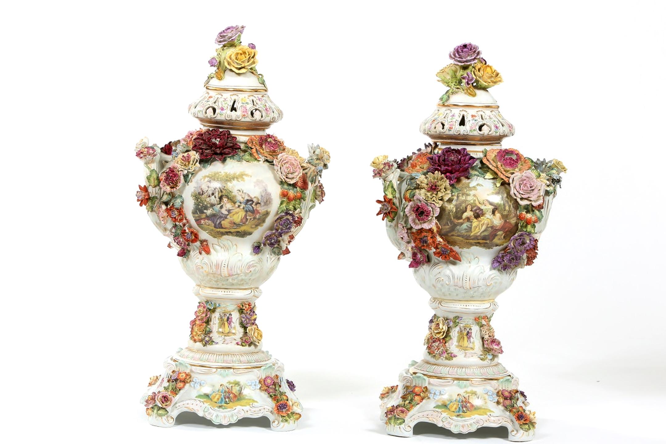 Impressive pair of German Dresden porcelain decorative covered urn, delicately painted overall with flowers and enhanced by clusters of porcelain flowers. Each piece is in great condition with wear consistent with age / use. Maker's mark