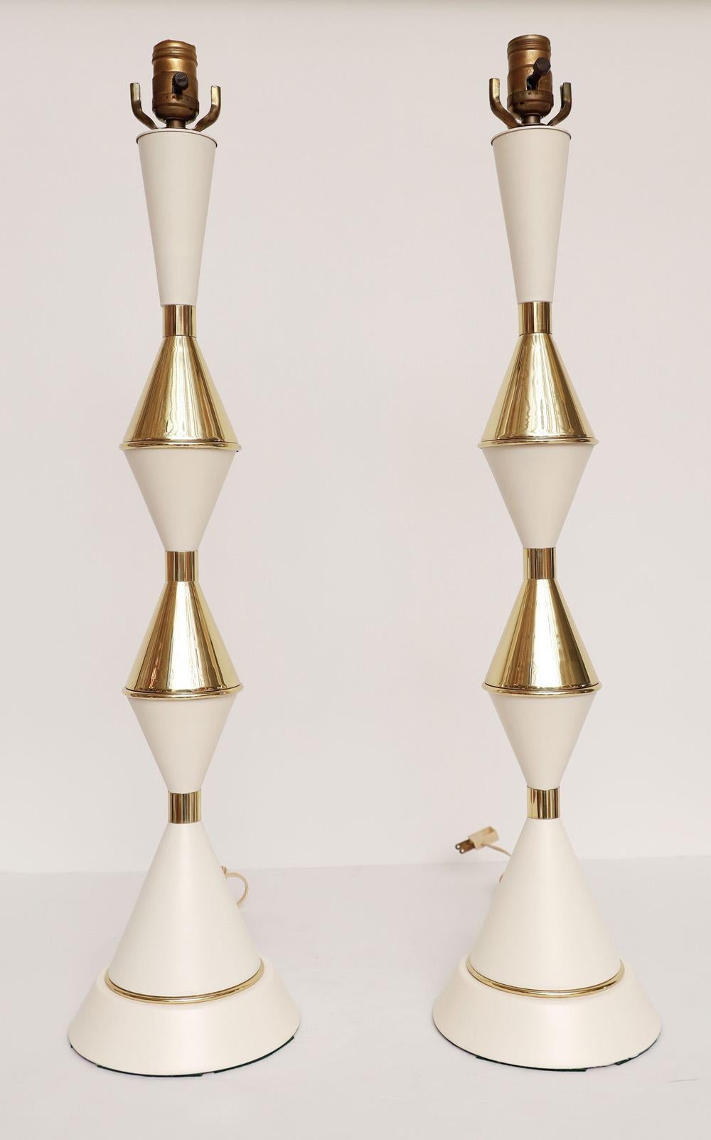 Majestic pair of 50's Polished brass and white lamps in the style of Tommi Parzinger. 
Tall and elegant, Perfect pair for a credenza or nightstands.

We love them!