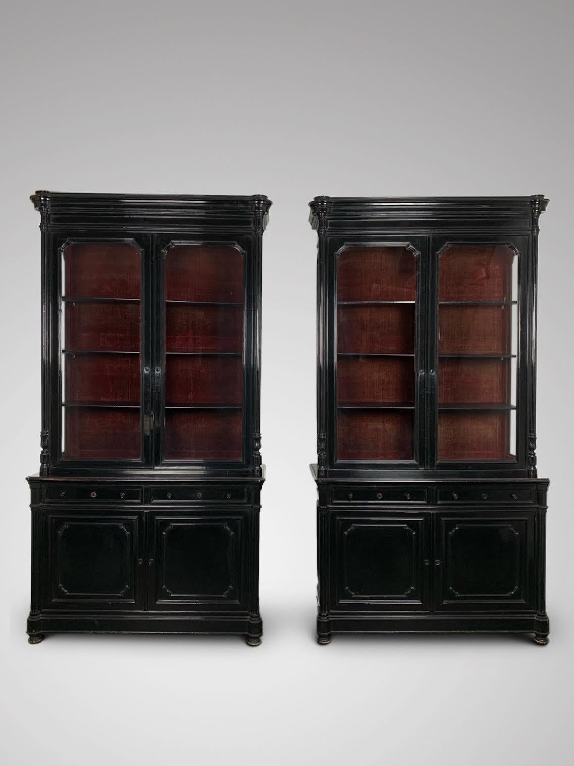 A stunning pair of impressive 19th century French ebonized cabinets or bookcases. Napoleon III Period. It features a rounded moulded cornice above a pair of shaped glazed doors, side panelled glass, flanked by a pair of carved, reeded and turned