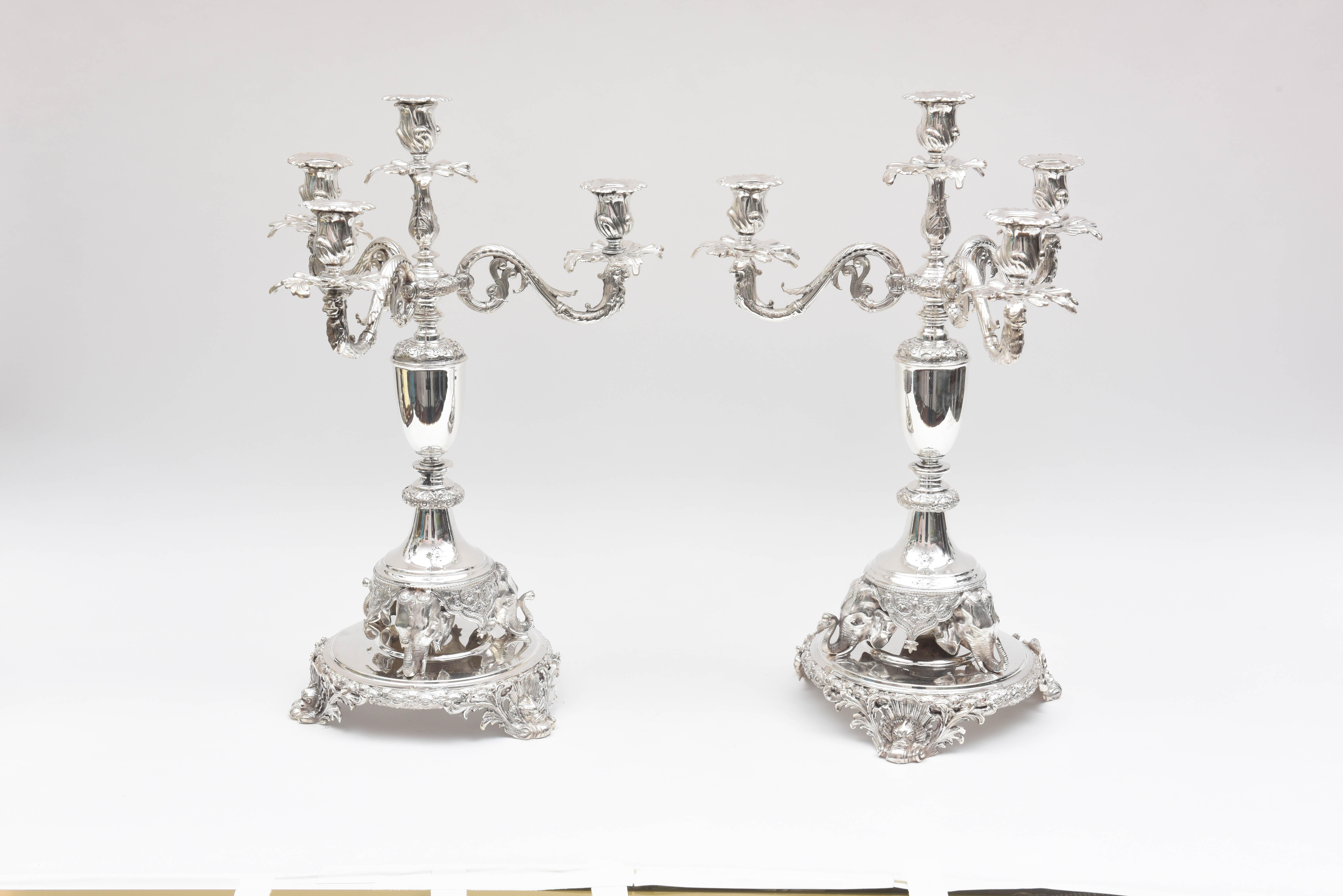 A tall and well chased set of 2 elegant candelabra with figural tripartite elephant feet. They are raised on scrolled platform bases with dolphin and shell flourishes to their feet. They are in fine vintage condition and are show stopping stunning.