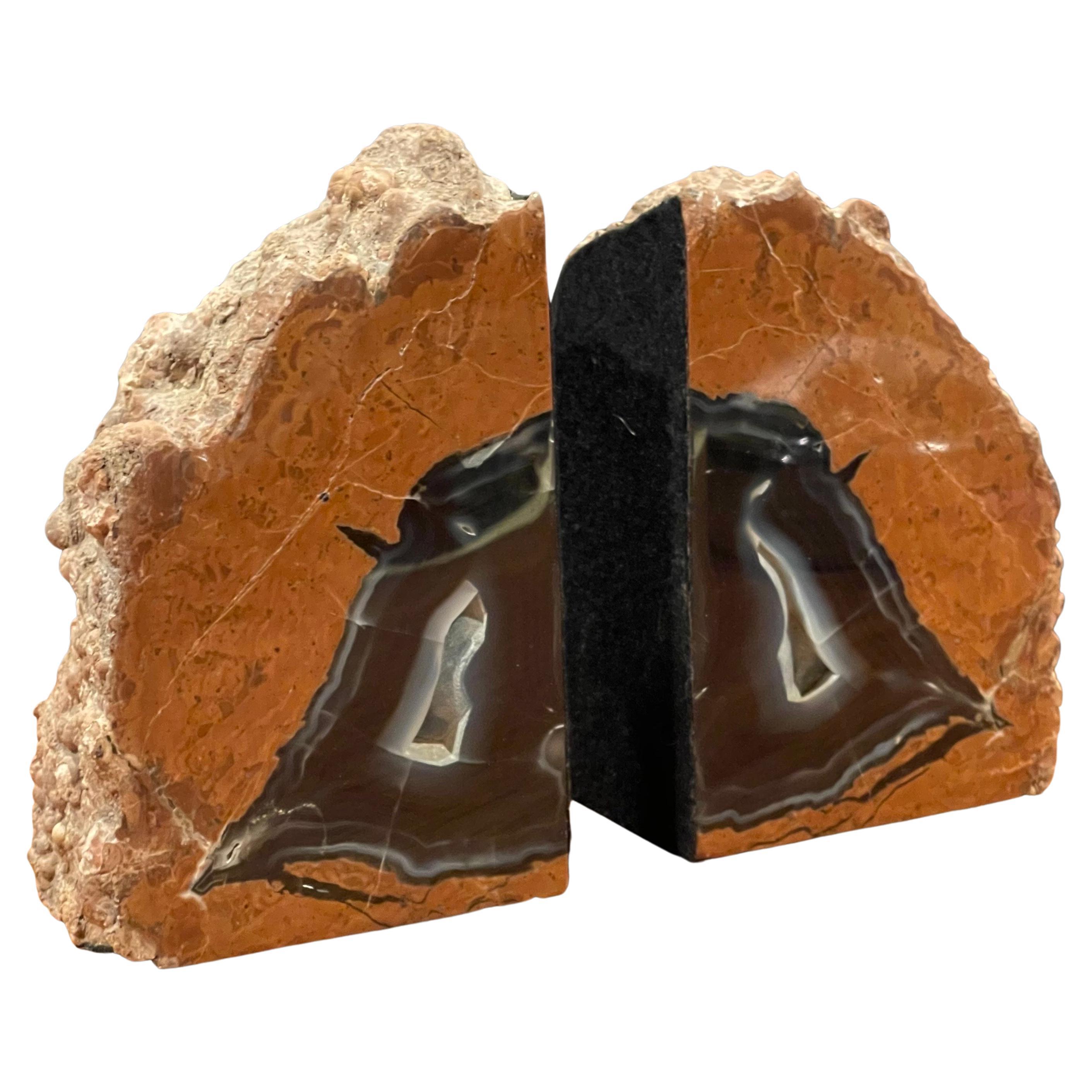 An impressive pair of banded agate bookends, circa pre-history. Brightly colored tan, brown and black tones with naturally formed patterns caused by fossilization over millions of years. Finished with a highly polished surface, the exterior edges