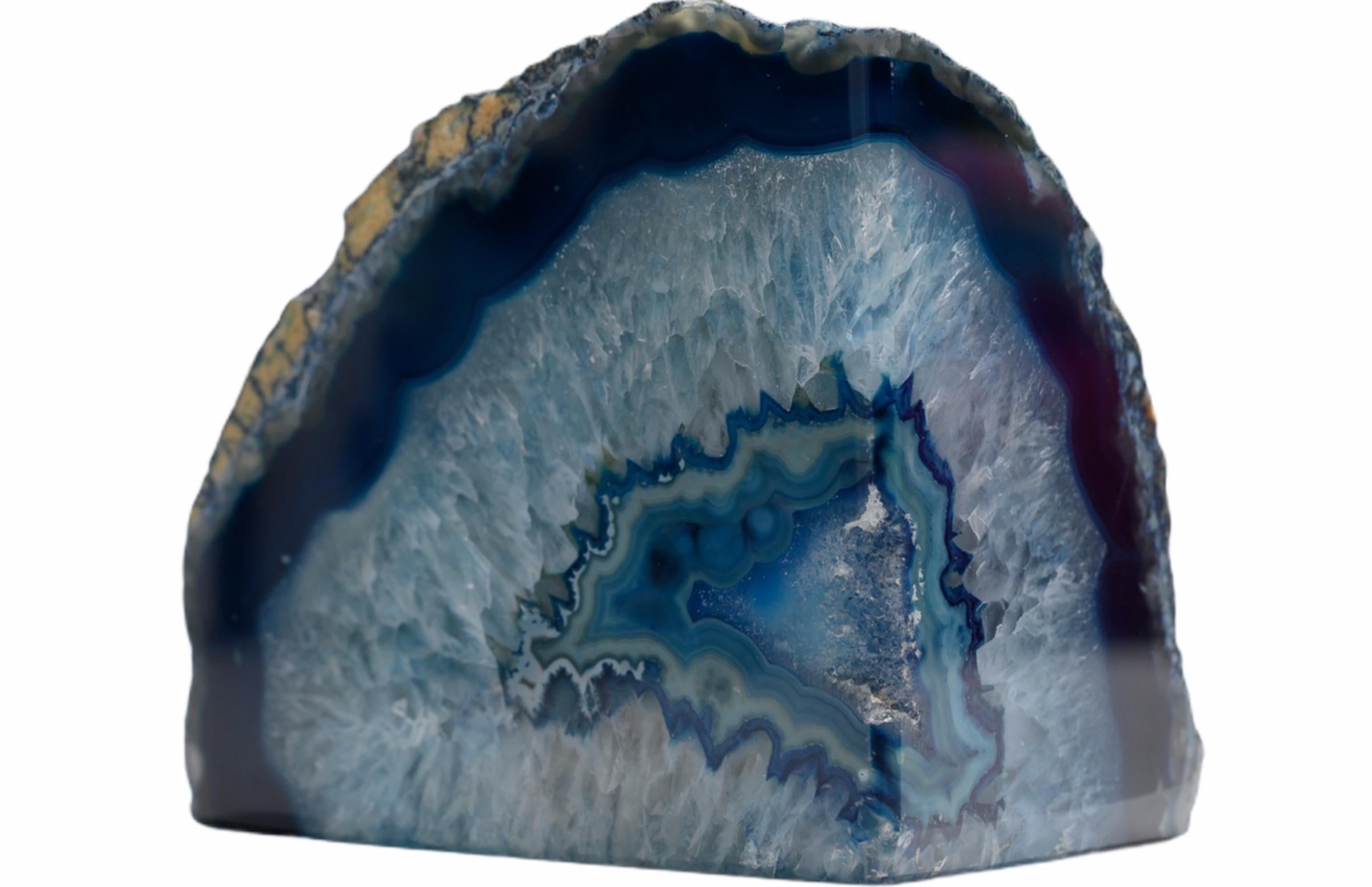 An impressive pair of blue organic geode bookends with a long history. Brightly colored with naturally formed patterns caused by fossilization over hundreds of years. Finished with a highly polished surface, the exterior edges retaining raw, organic