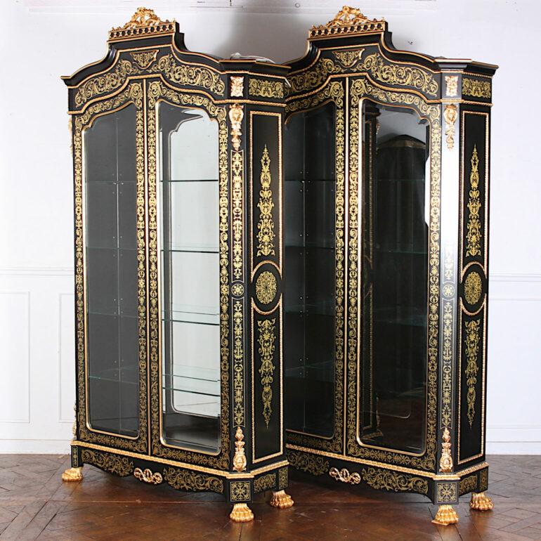 Unusual and striking pair of vintage French black lacquer and gilt cabinets or vitrines, each with two doors with curved bevelled glass edges opening to adjustable glass shelves. The cases are embellished throughout with gold leaf stencilling and