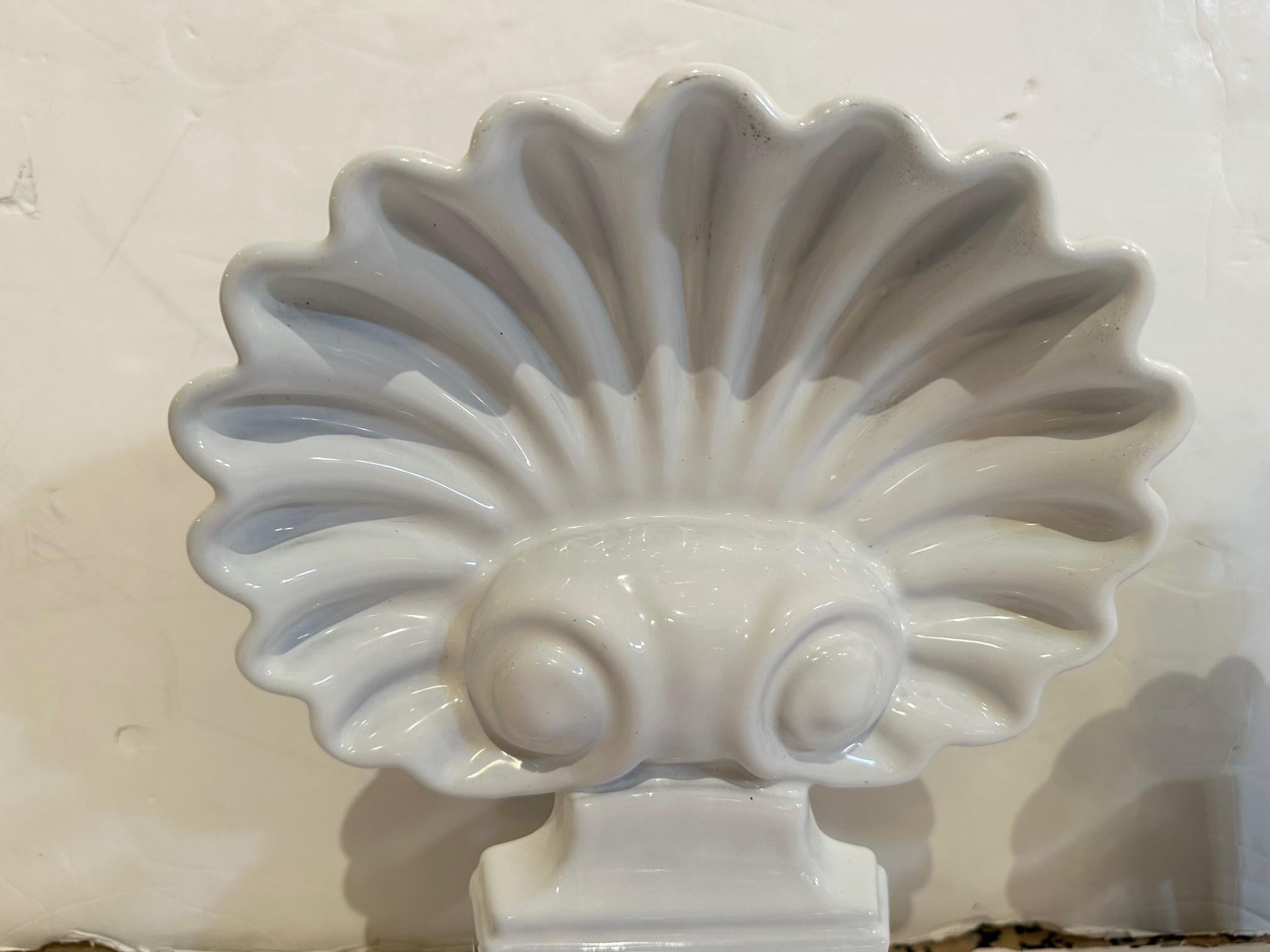 Stunning pair of white enameled cast iron shell motif sculptures, perfect for a mantel statement.  These were refashioned andirons cut down to fit on top of a mantel in Palm Beach.


