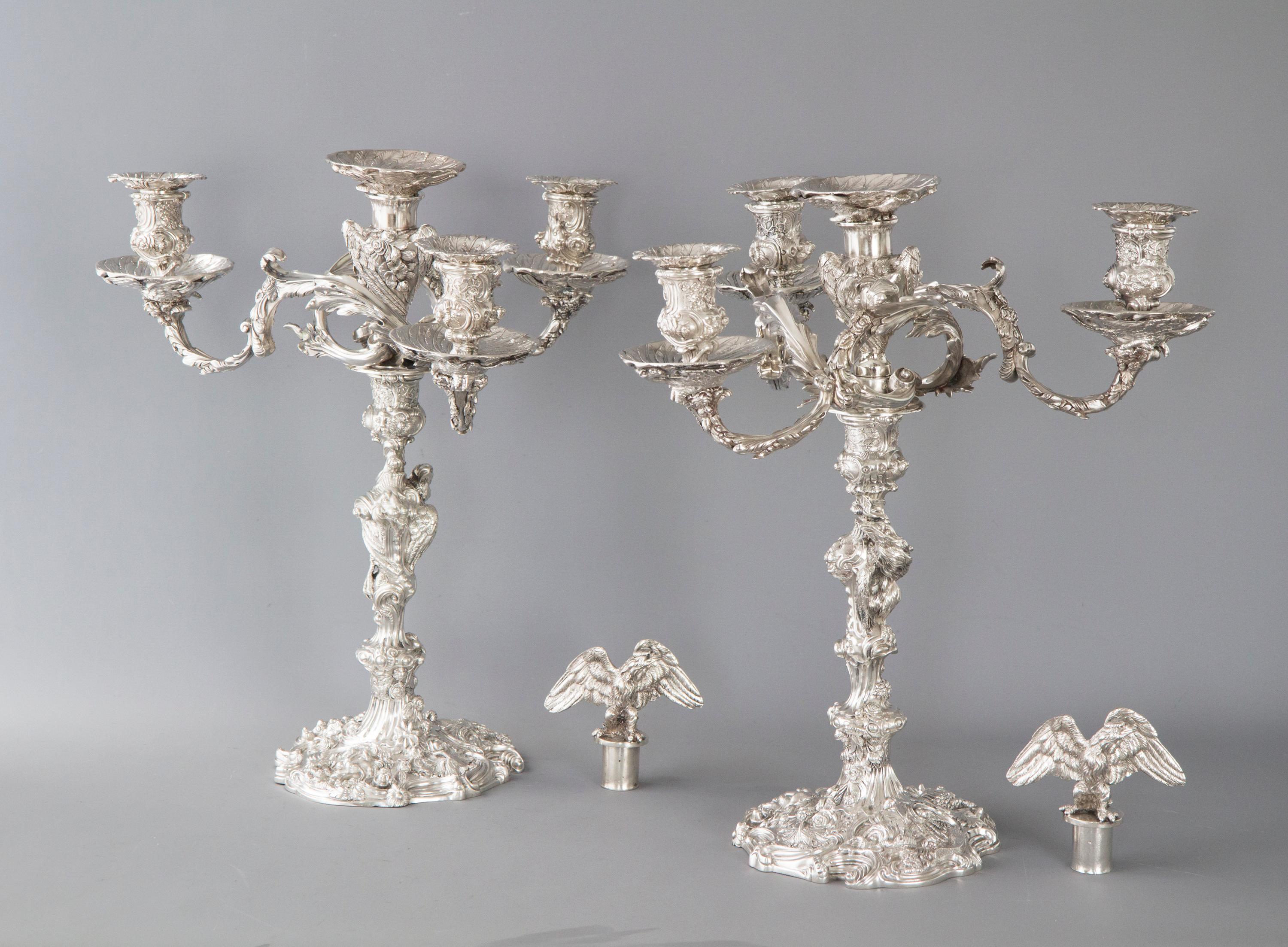 An outstanding and finely cast pair of George III silver candelabra modeled in the neo-rococo style. Each standing on a shaped circular base rising to a knopped baluster stick. The removable arms with three scrolling foliate branches leading to