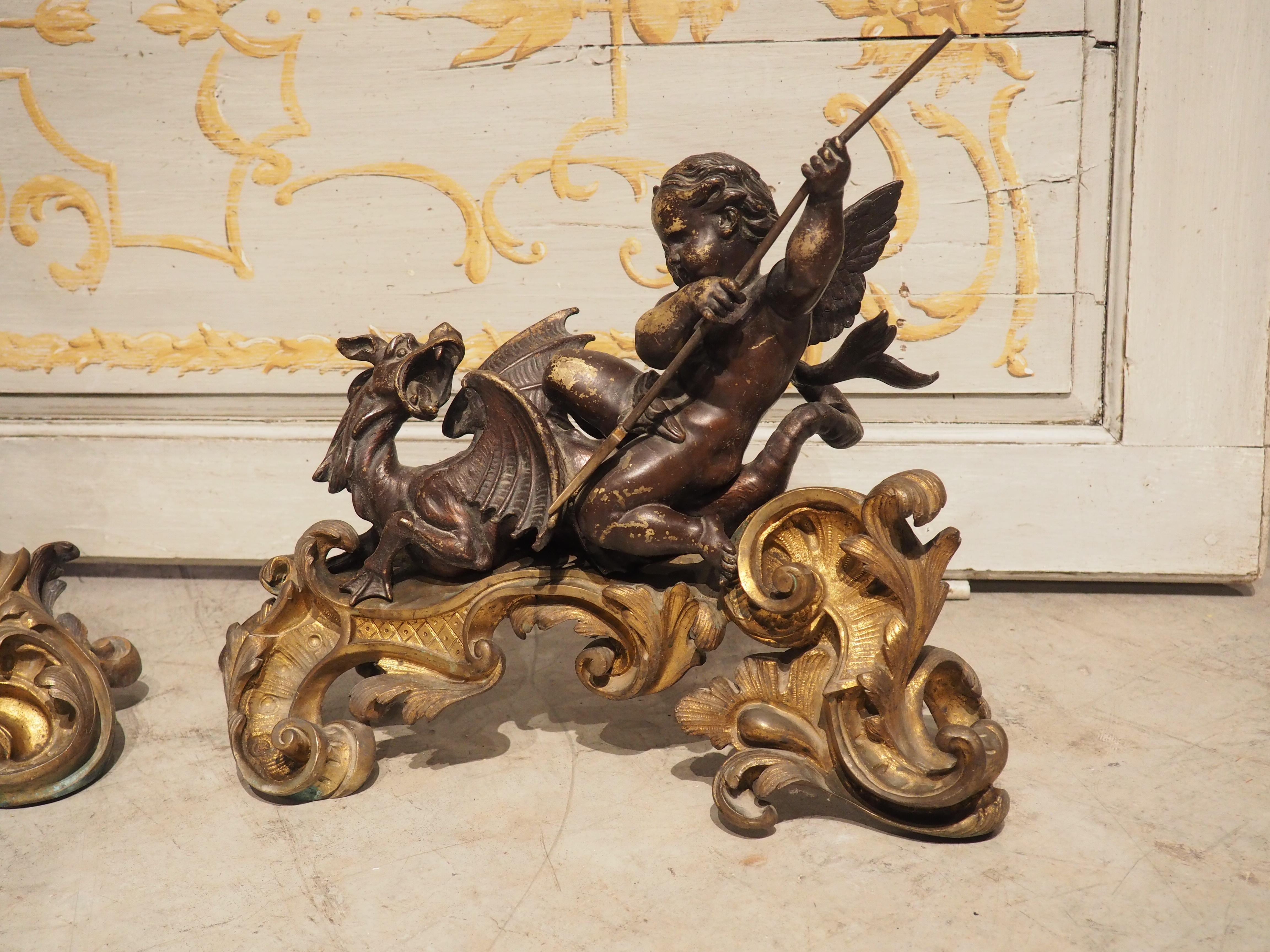 This dynamic pair of French bronze chenets with putti and sea dragons was crafted circa 1850. The dore Rococo bases are full of life, with golden pierced and attenuated leaves, volutes, scrolls, and pebbles; they are reminiscent of the movement of