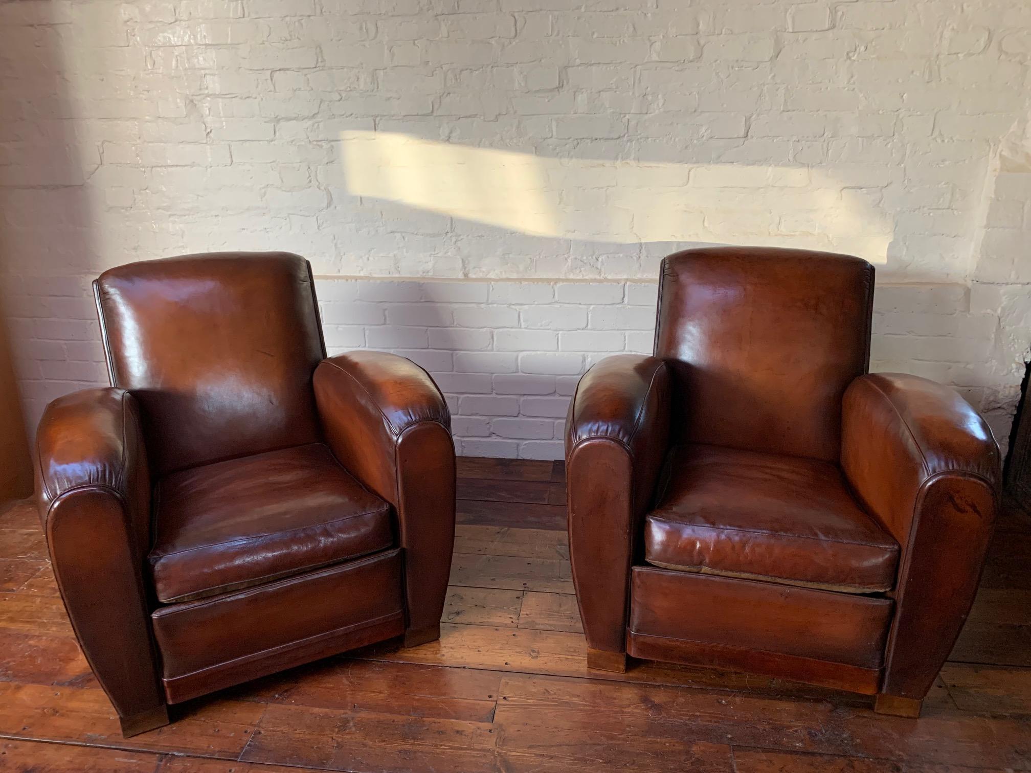 This is a beautiful pair of original French Leather club chairs. The original Havana brown leather has been preserved beautifully and through areas of wear now reveal the loveliest of chestnut hues. Fast approaching 80 years, these chairs have been