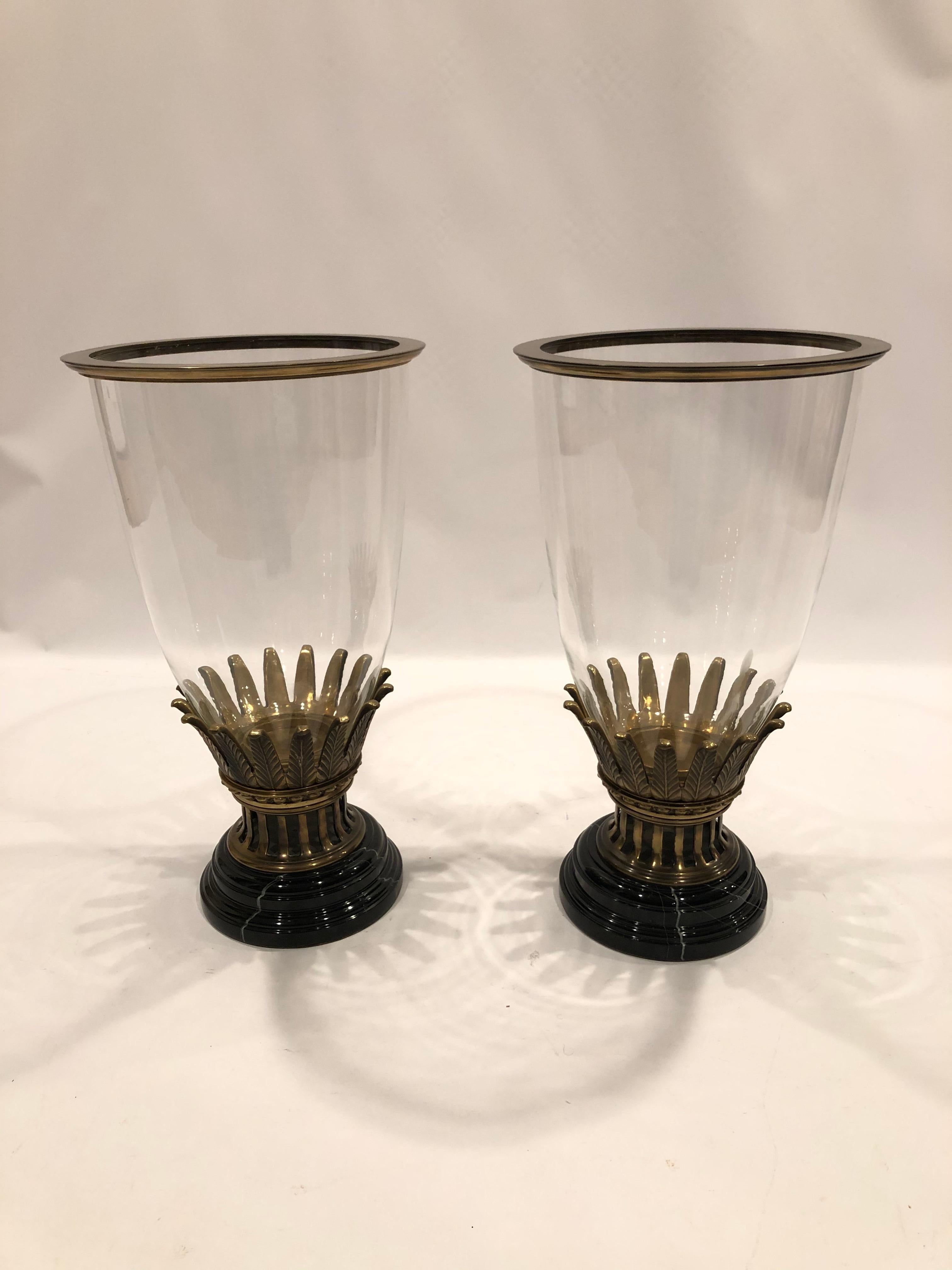 Large gutsy very impressive pair of glass hurricanes having bronze and black marble bases. There are very decorative bronze crowns that hold the thin elegant glass domes, and round discs unscrew to hold the glass in place. Beautifully engineered and