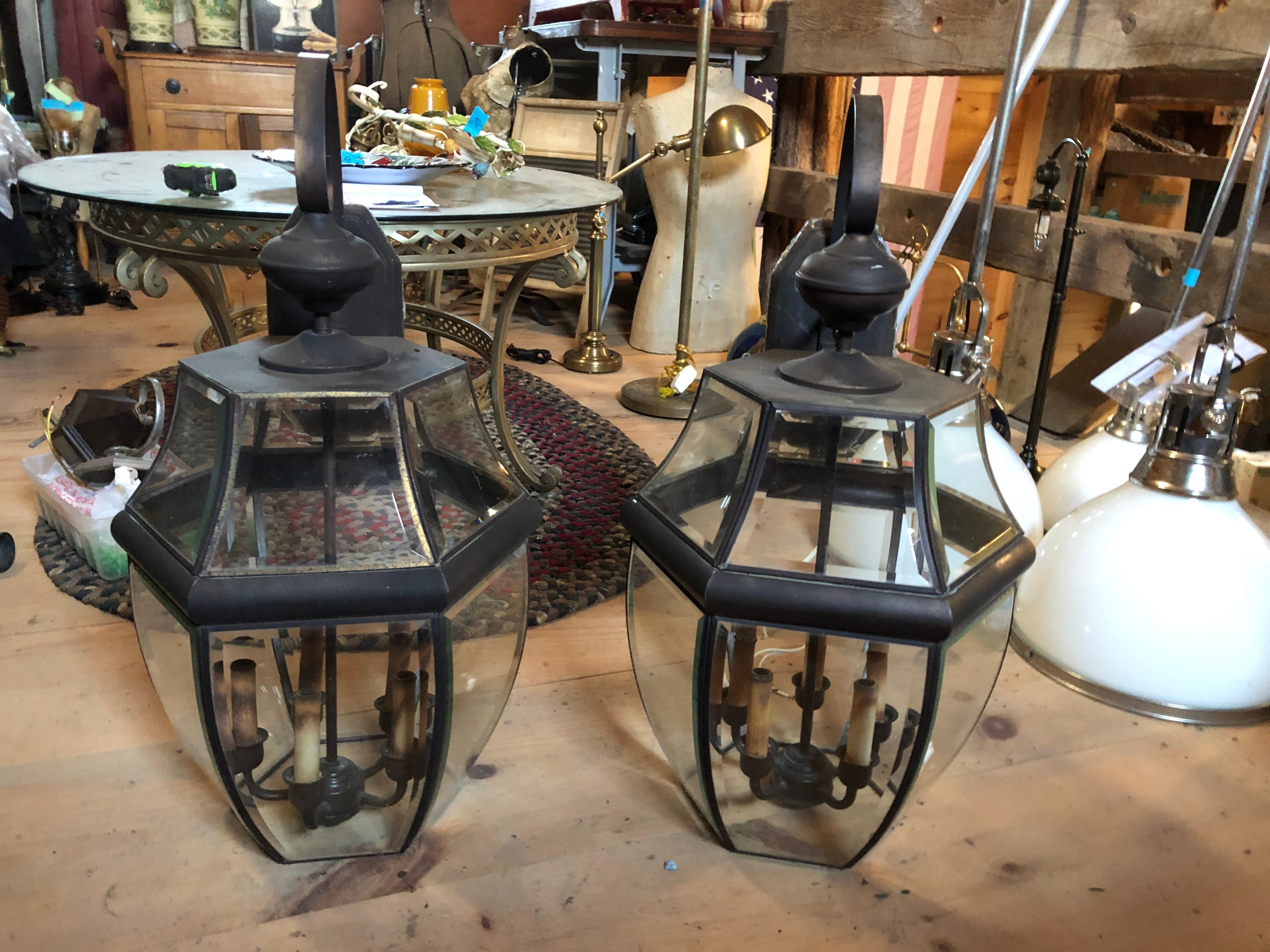 Stunning & impressive in scale large metal and beveled glass lanterns that mount on the wall.  Can be used inside or outside.  Interior to the lantern are 4 candle sockets.