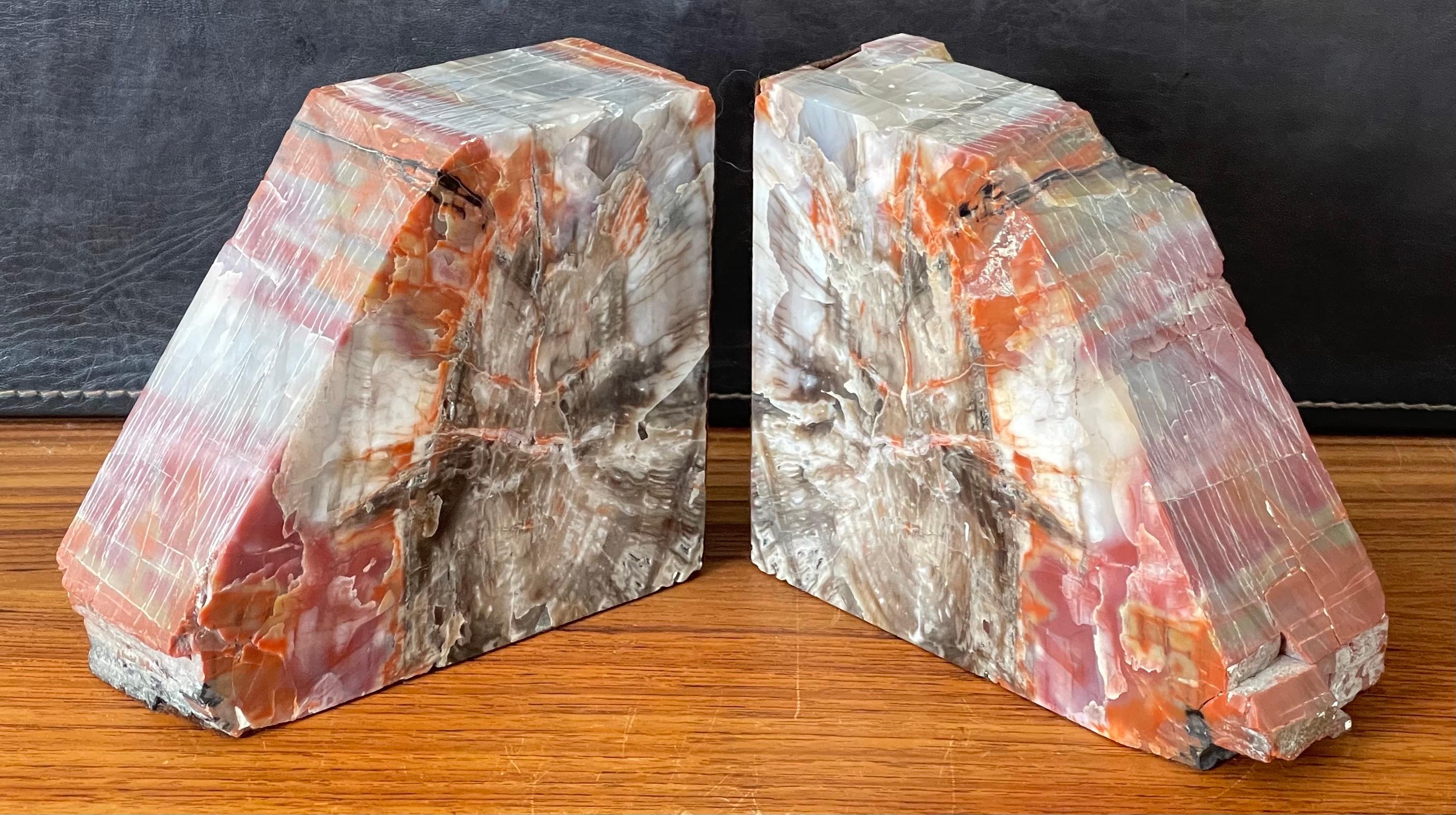 An impressive pair of large petrified wood bookends, circa pre-history from Arizona. Brightly colored tan, cream, grey, black and red tones with naturally formed patterns caused by fossilization over millions of years. Finished with a highly