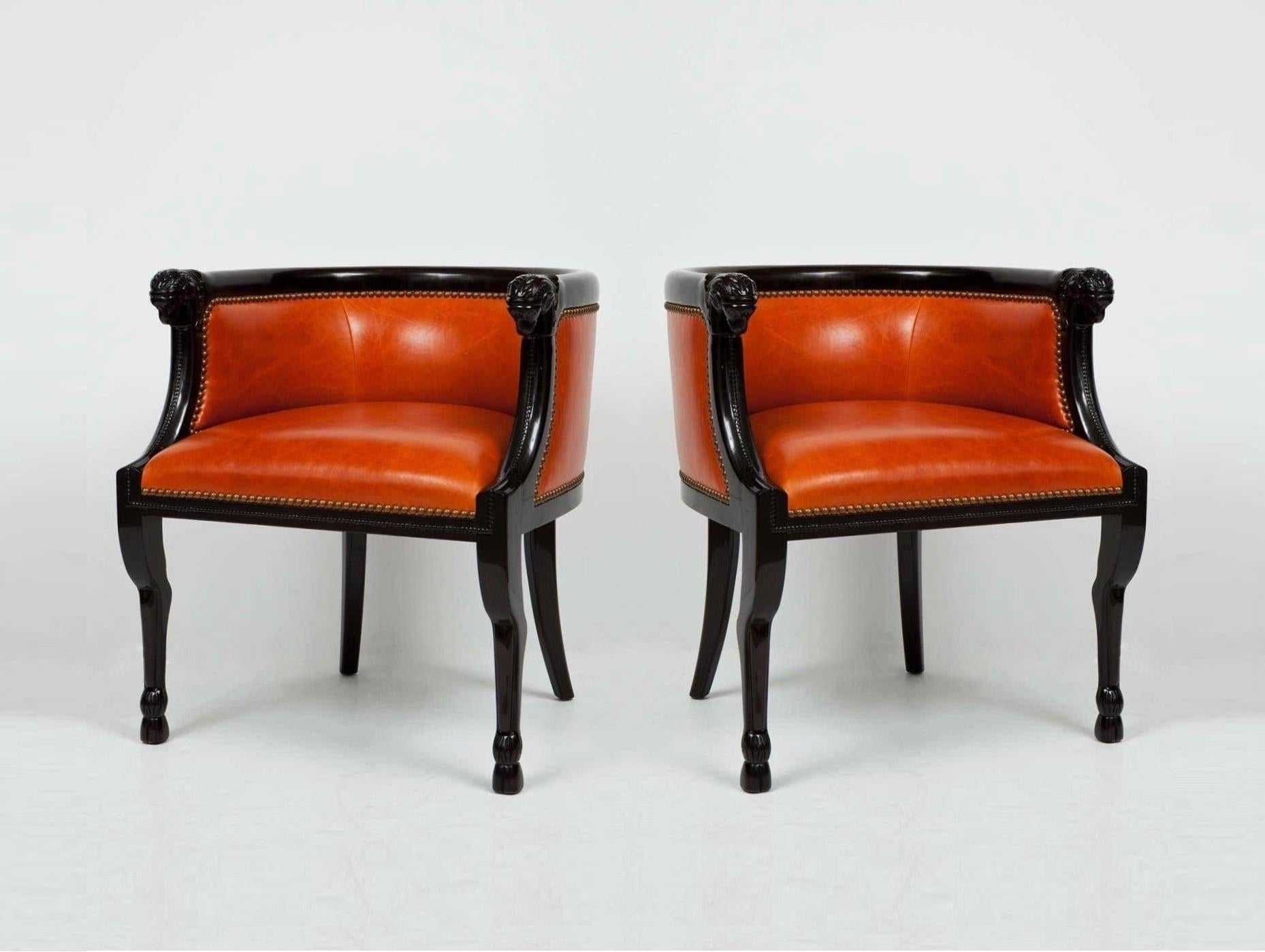 Tailored stately pair of professionally lacquered bergères. These armchairs feature a barrel back including a rounded edge over an upholstered inset panel with finely carved ram's head hand holds. The gentle curve from the back along the arm is very