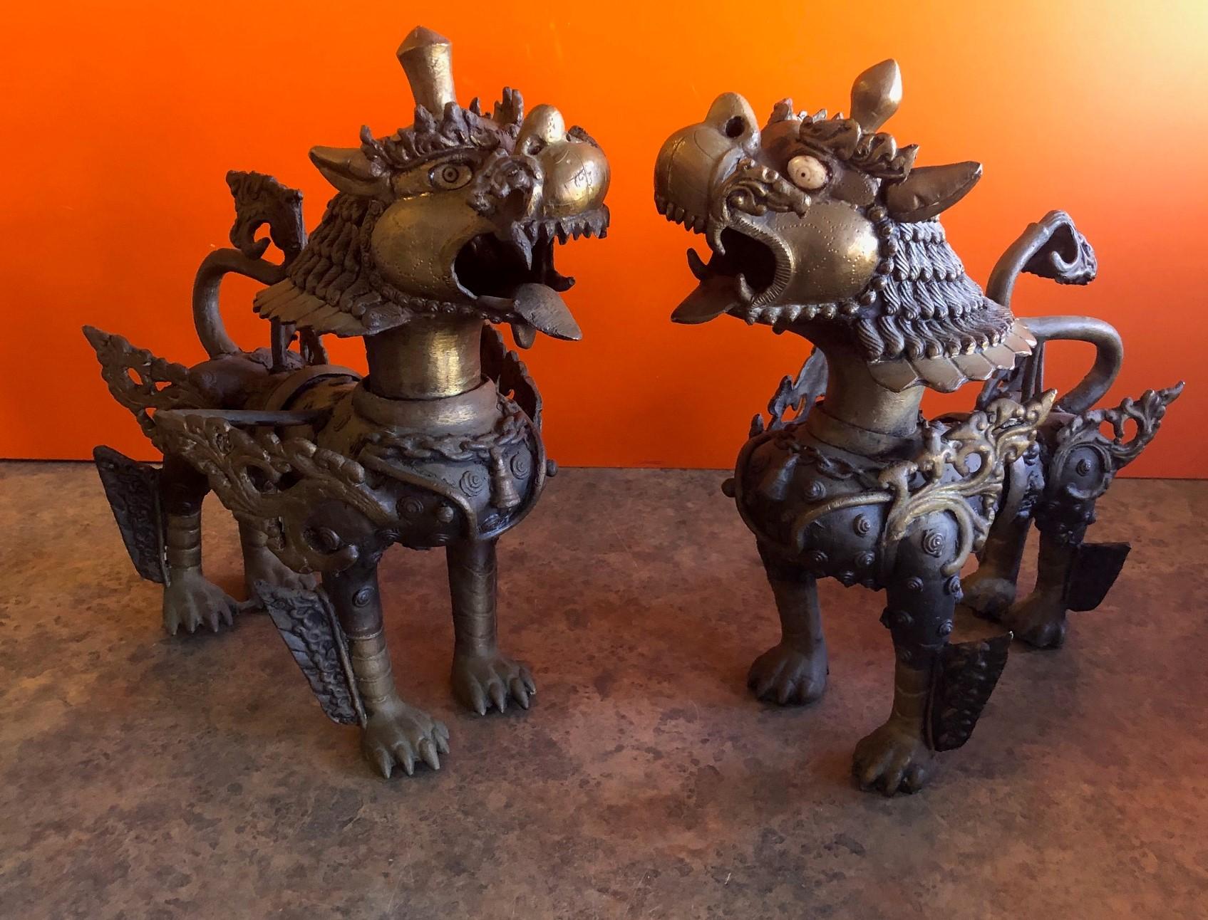 Impressive pair of large patinated bronze Chinese foo dogs or Tibetan snow lions in full armor, circa 1930s. Tibetan snow lions are known for protective qualities; they are celestial animal emblem of Tibet that embodies power, playfulness,